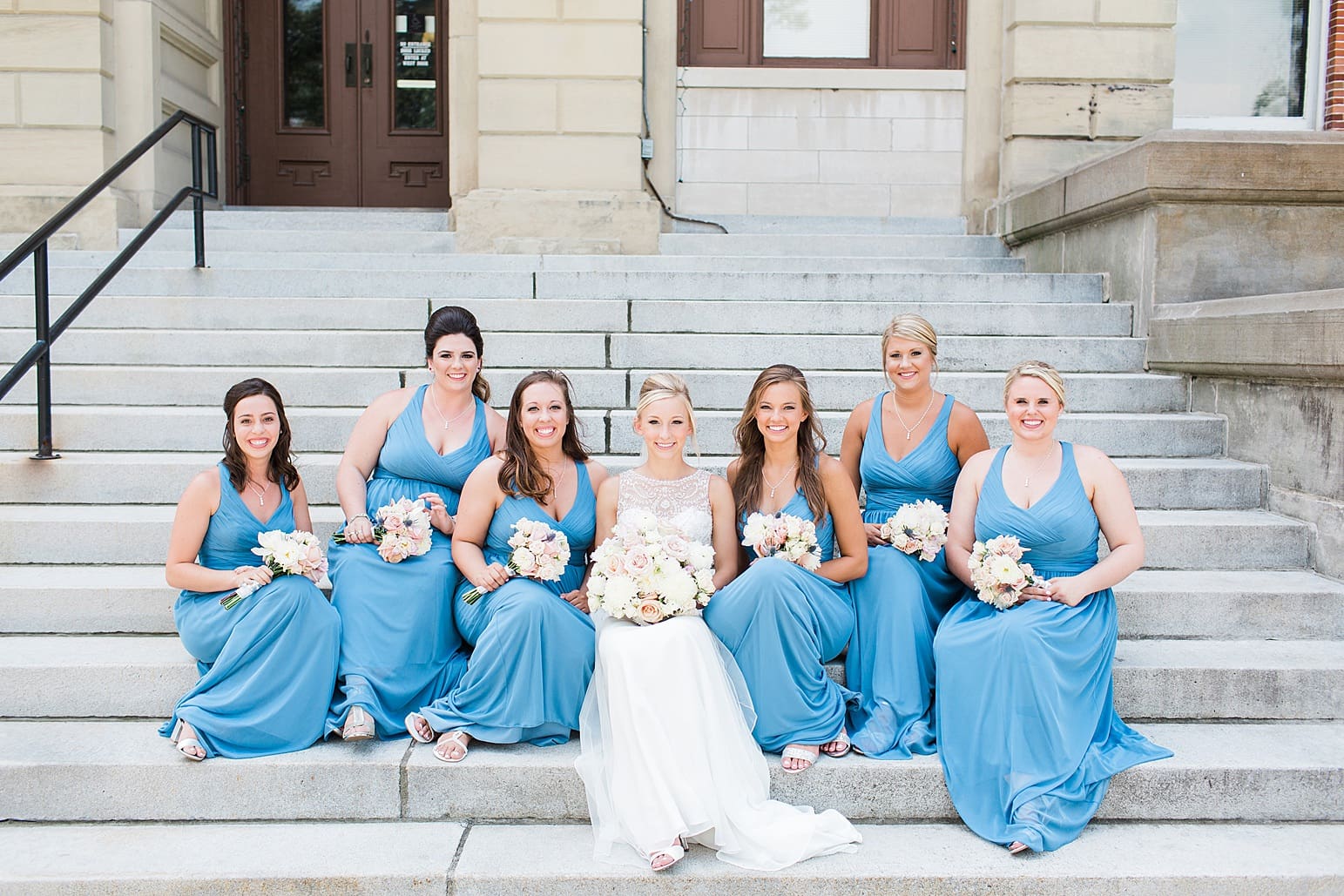 Arielle Peters Photography | Bride and bridesmaids sitting on church steps on wedding day at the Spohn Ballroom in Goshen, Indiana.
