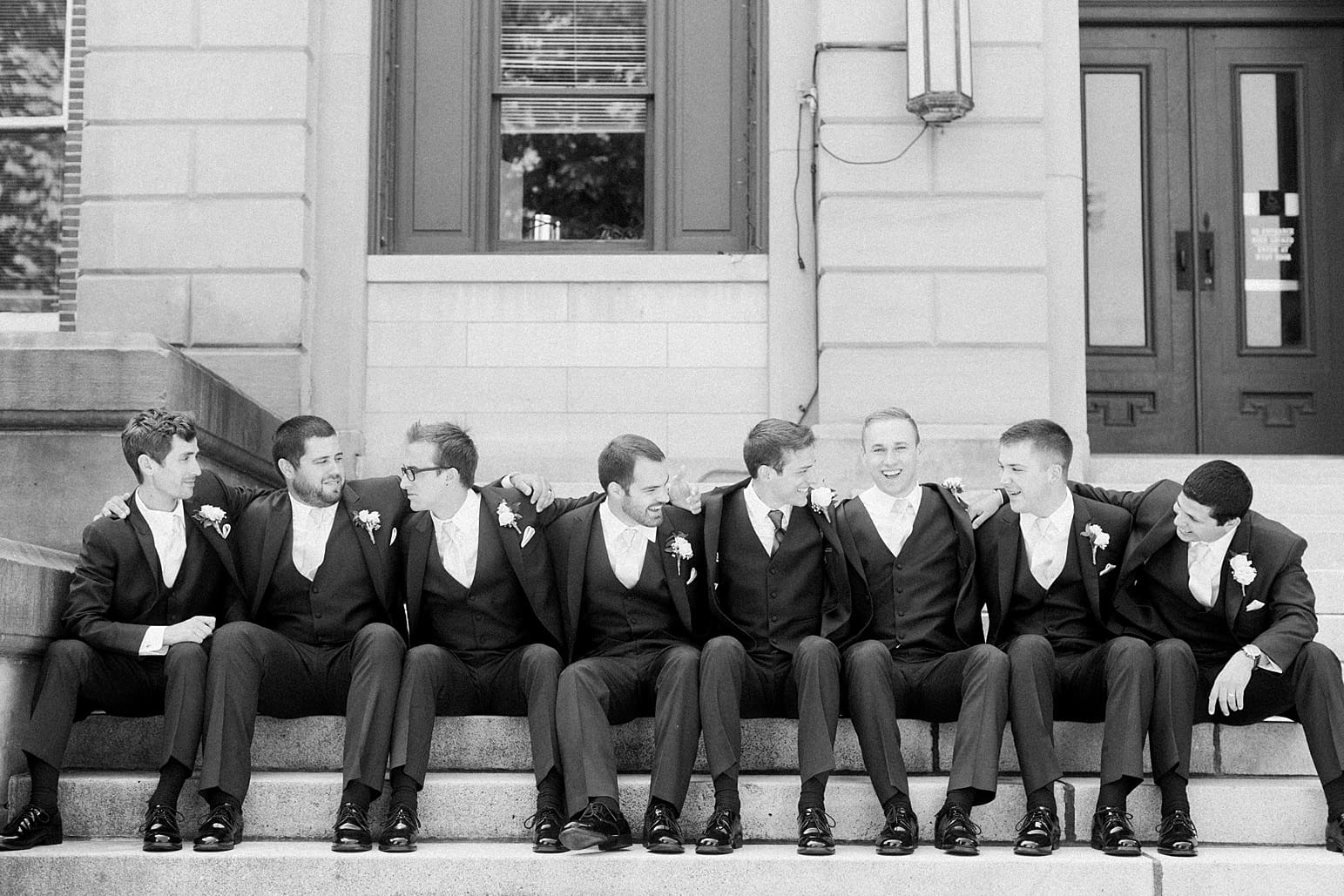 Arielle Peters Photography | Groom and groomsmen sitting on church steps on wedding day at the Spohn Ballroom in Goshen, Indiana.