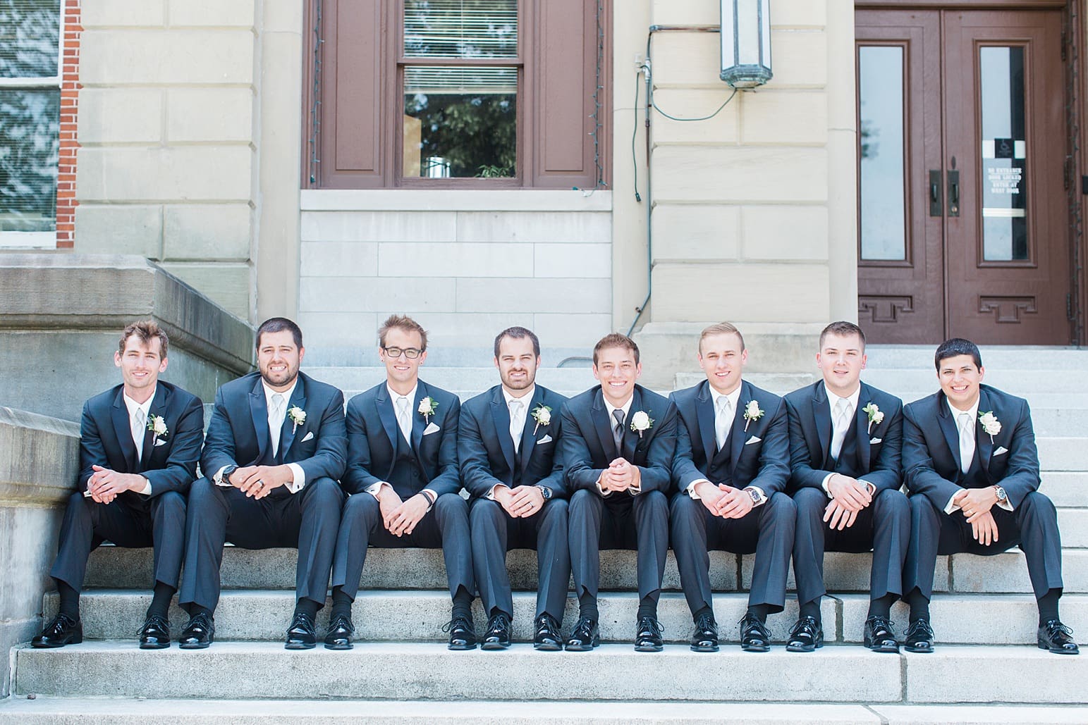 Arielle Peters Photography | Groom and groomsmen sitting on church steps on wedding day at the Spohn Ballroom in Goshen, Indiana.