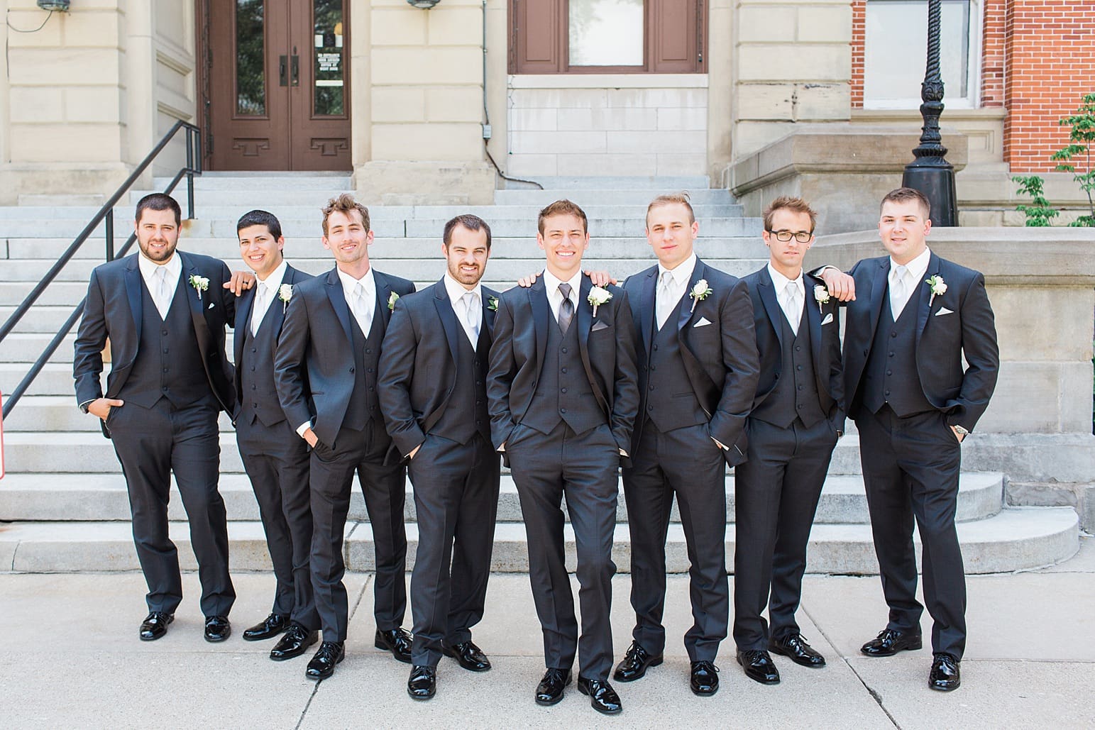 Arielle Peters Photography | Groom and groomsmen standing outside brick church on wedding day at the Spohn Ballroom in Goshen, Indiana.