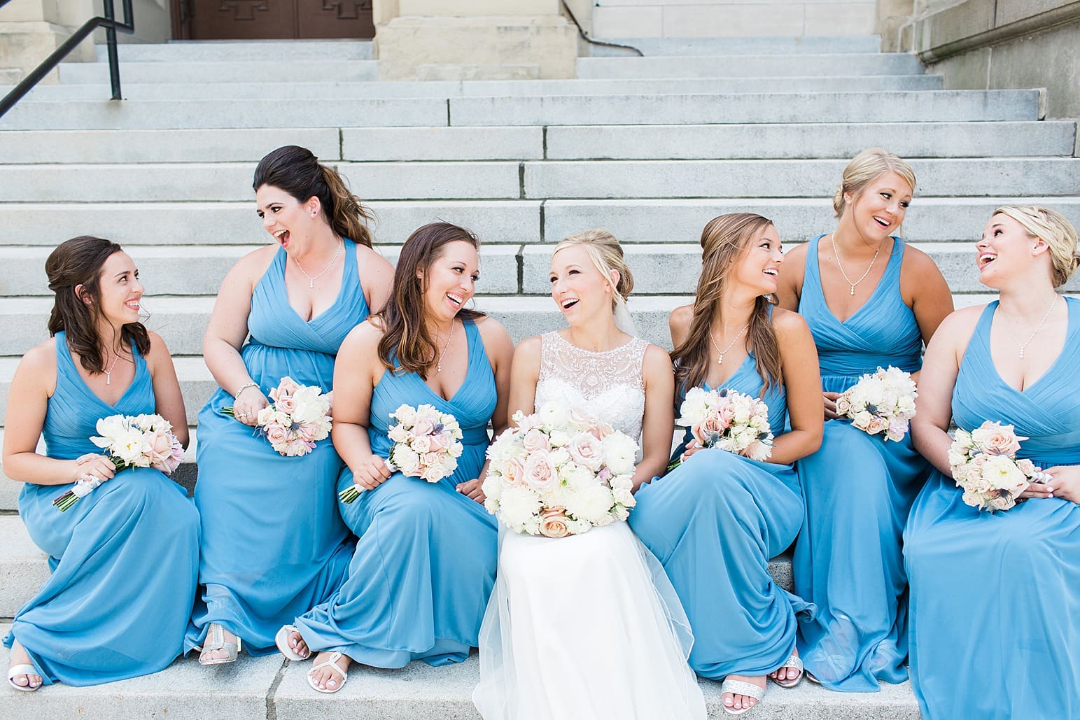 Arielle Peters Photography | Bride and bridesmaids sitting on church steps on wedding day at the Spohn Ballroom in Goshen, Indiana.