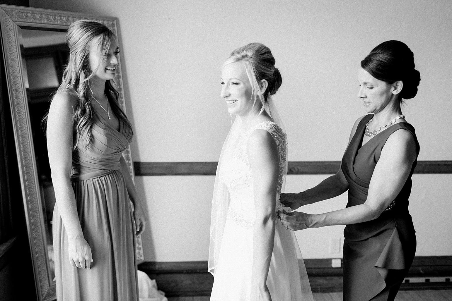 Arielle Peters Photography | Mother and sister of bride helping bride get ready on wedding day at the Spohn Ballroom in Goshen, Indiana.