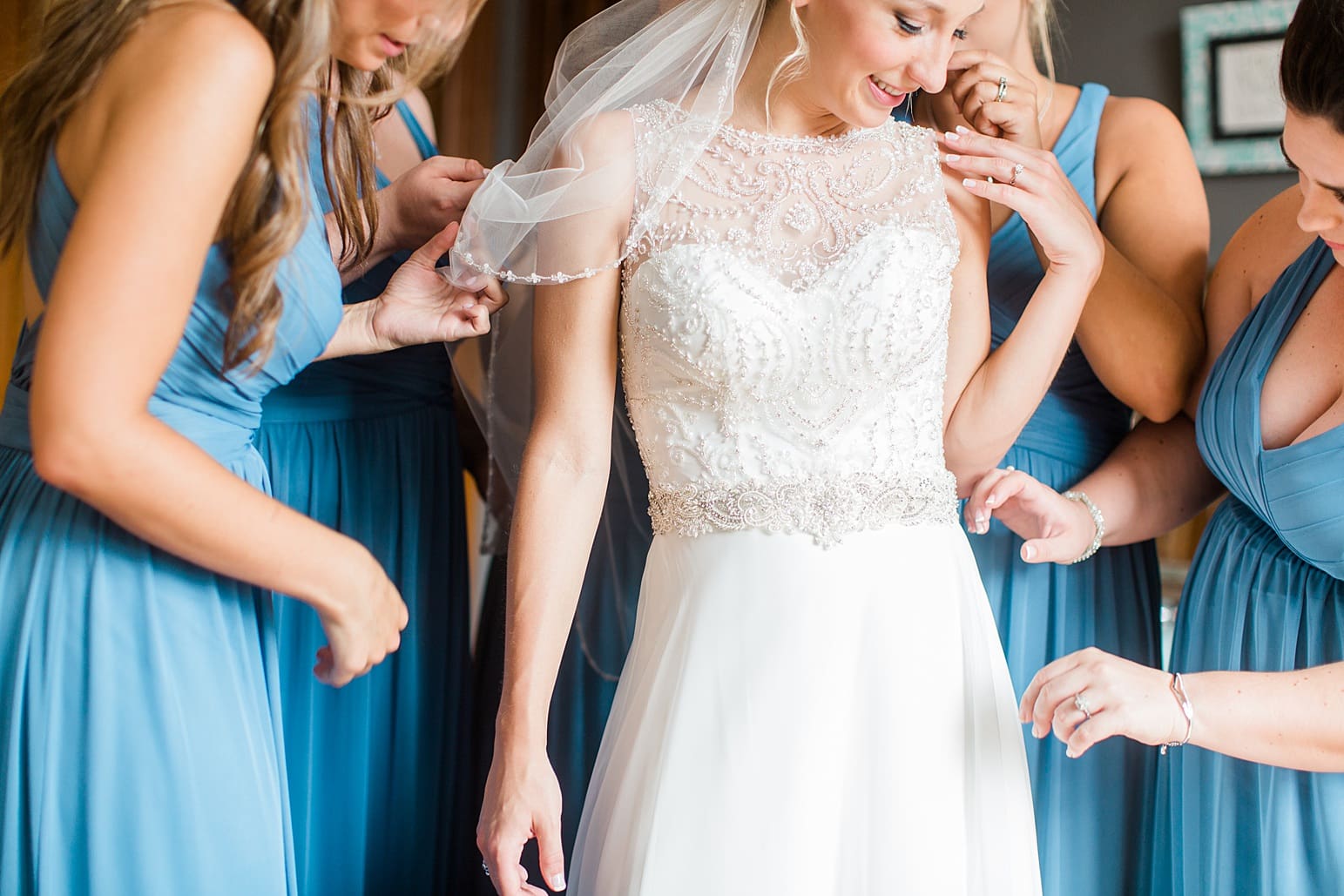 Arielle Peters Photography | Bridesmaids helping bride get ready on wedding day at the Spohn Ballroom in Goshen, Indiana.