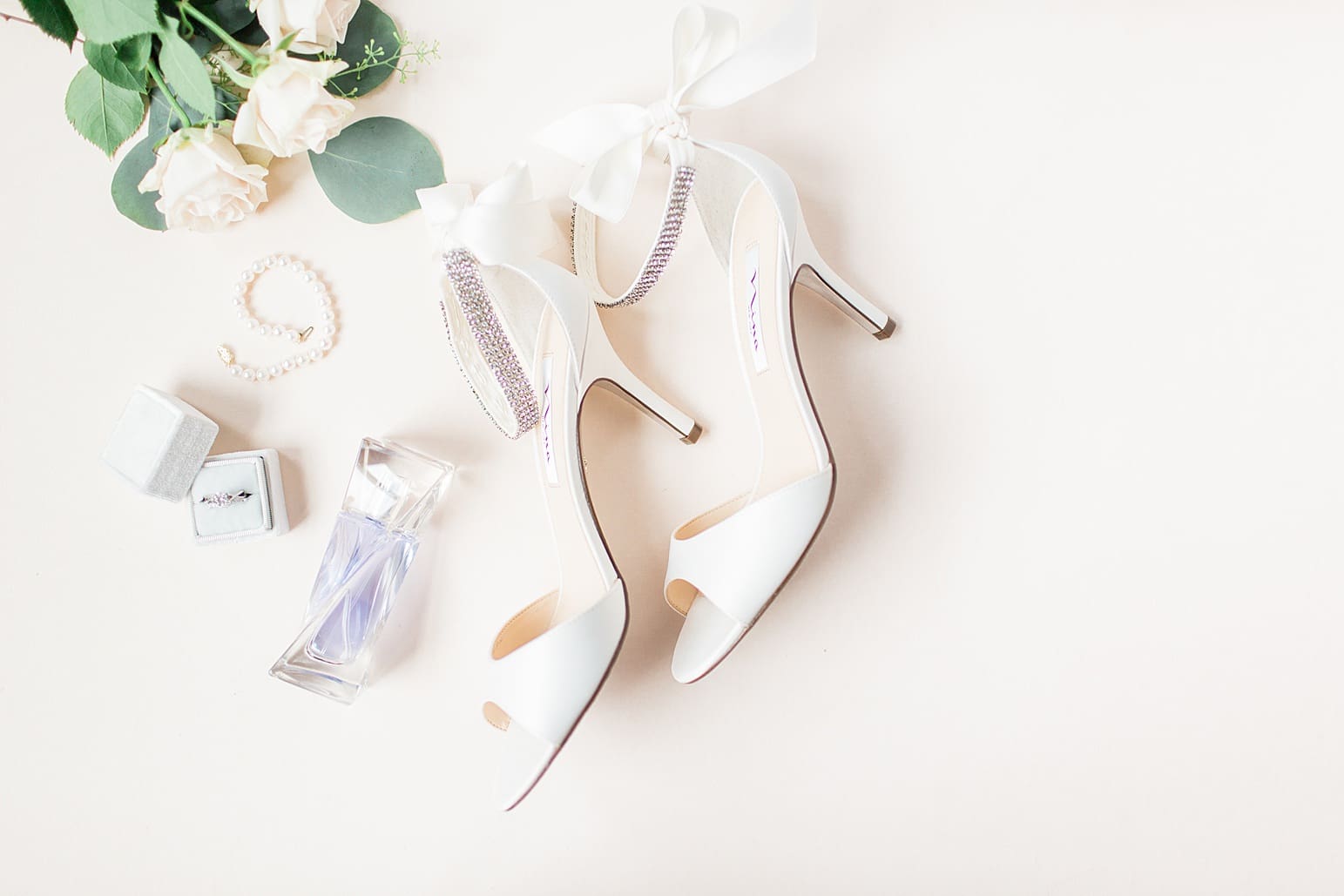 Arielle Peters Photography | Wedding shoes and jewelry on cream background on wedding day at the Spohn Ballroom in Goshen, Indiana.