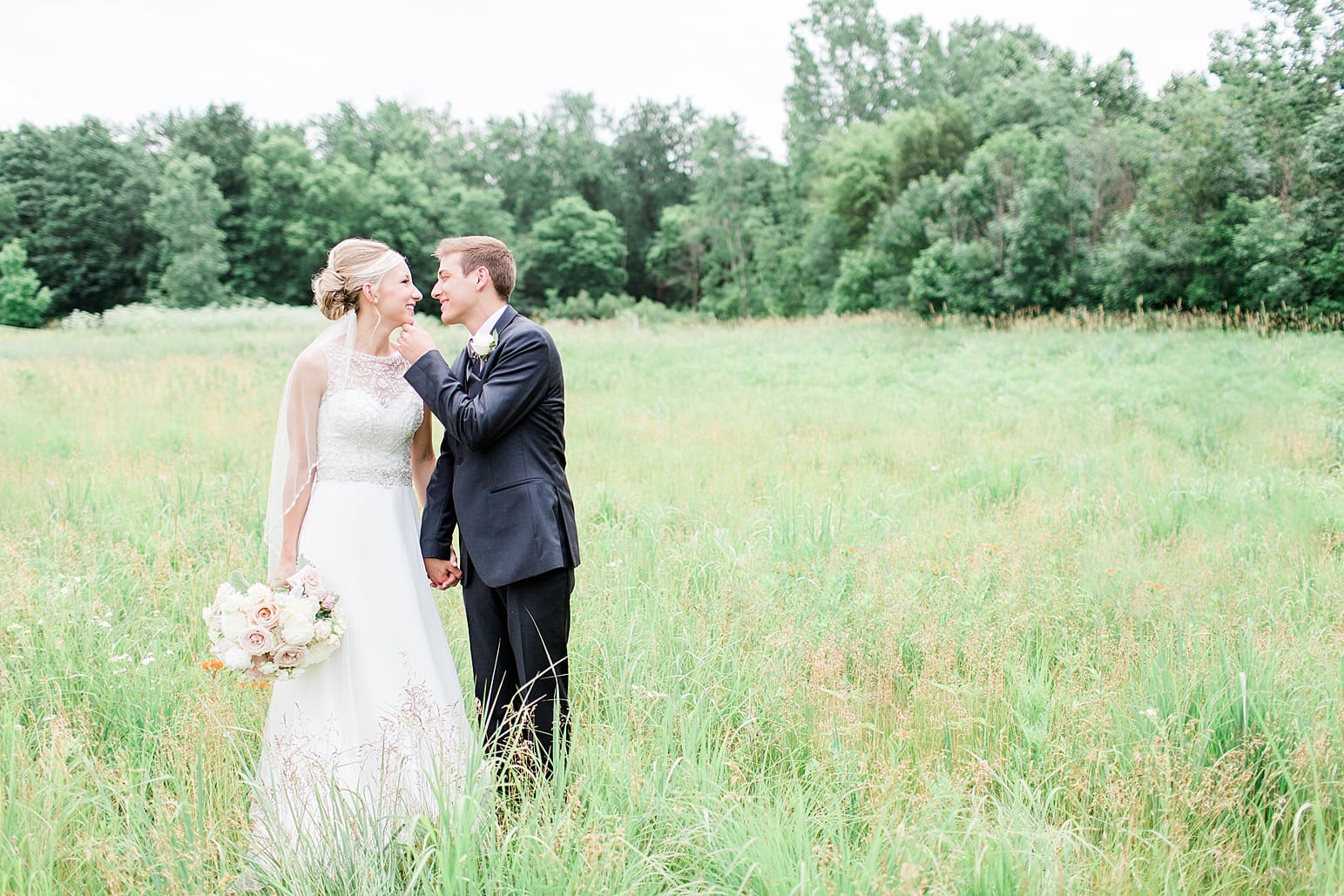 Arielle Peters Photography | Bride and groom walking in open field on wedding day at the Spohn Ballroom in Goshen, Indiana.