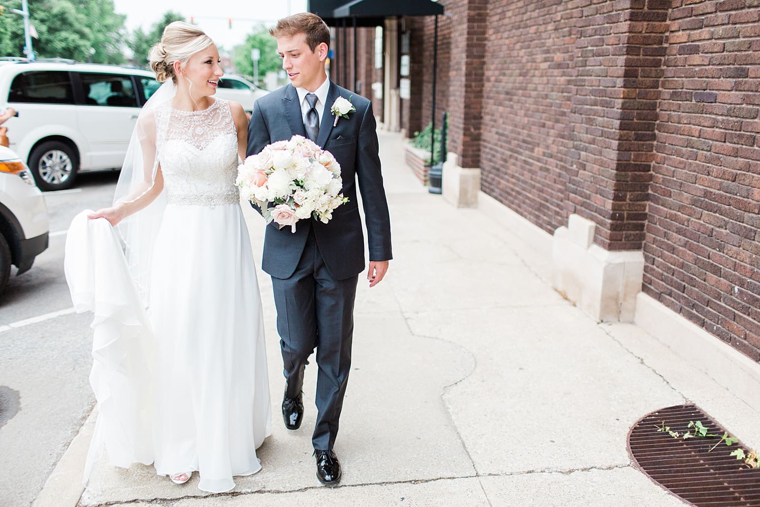 Arielle Peters Photography | Bride and groom walking on city streets on wedding day at the Spohn Ballroom in Goshen, Indiana.
