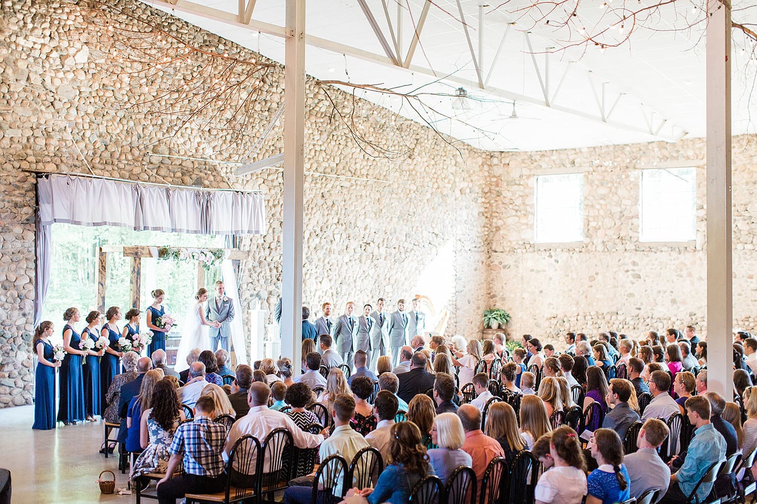Arielle Peters Photography | Bride and groom holding hands at the alter on wedding day at Lawton Lions Heritage Community Center in Lawton, Michigan.