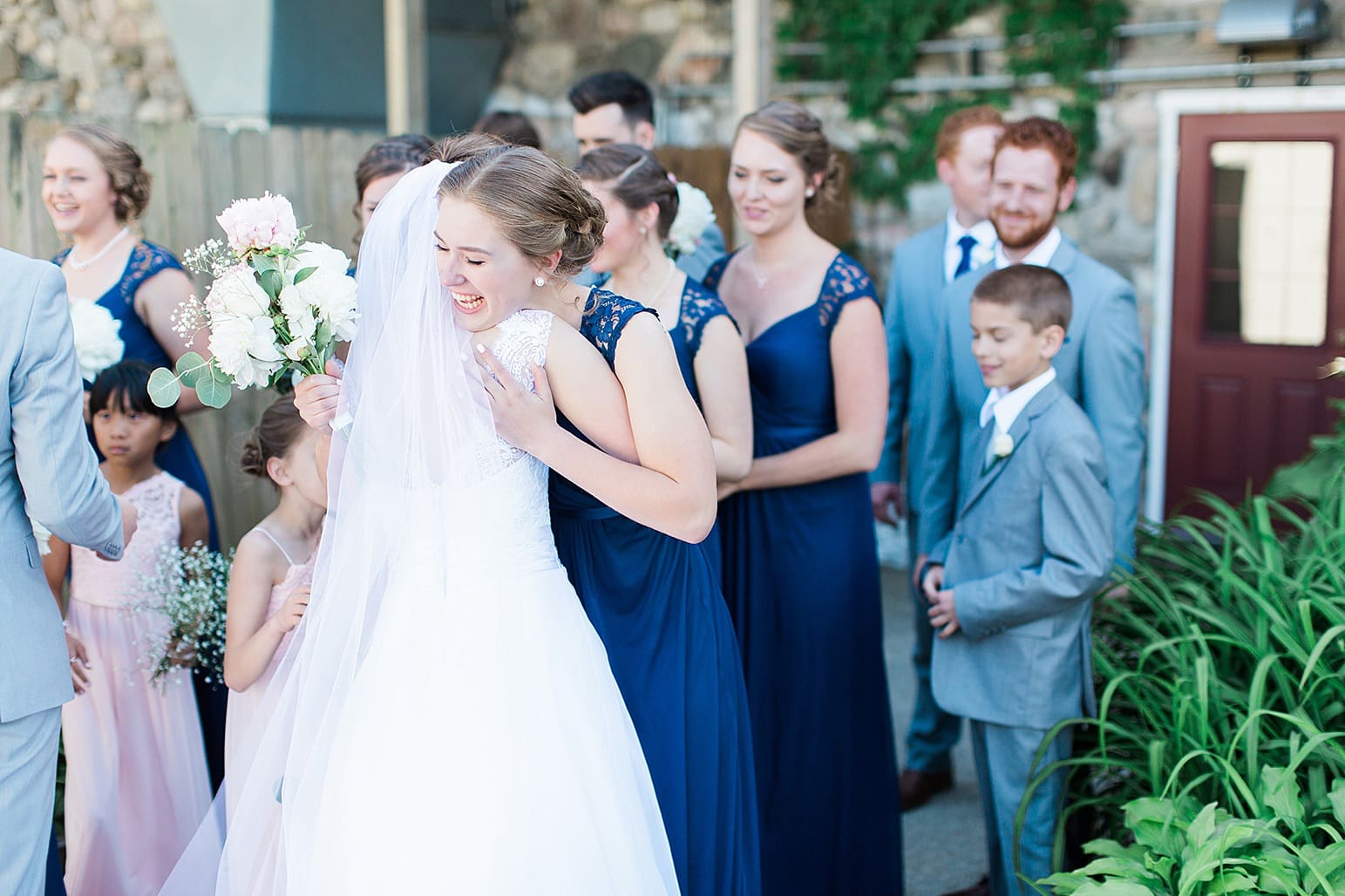 Arielle Peters Photography | Bride and bridesmaid hugging on wedding day at Lawton Lions Heritage Community Center in Lawton, Michigan.