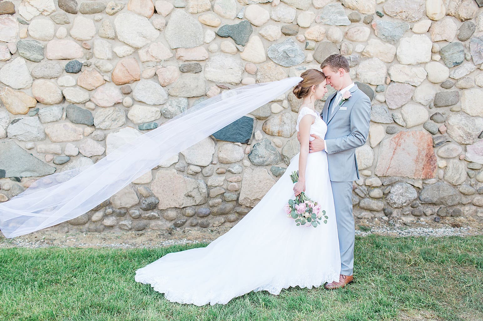 Arielle Peters Photography | Bride and groom in front of historic cobblestone building on wedding day at Lawton Lions Heritage Community Center in Lawton, Michigan.