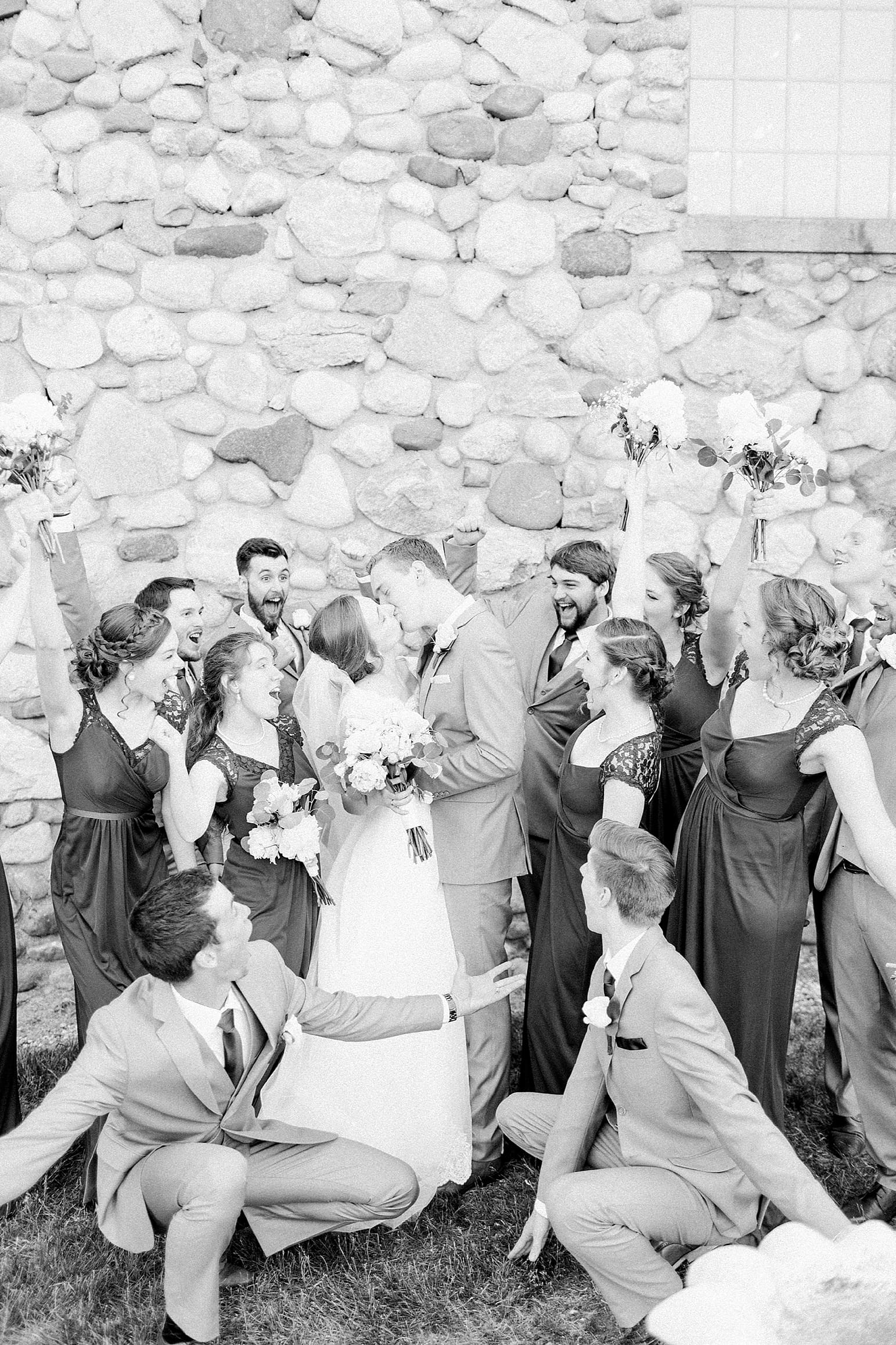 Arielle Peters Photography | Wedding party cheering for bride and groom in front of historic cobblestone building on wedding day at Lawton Lions Heritage Community Center in Lawton, Michigan.