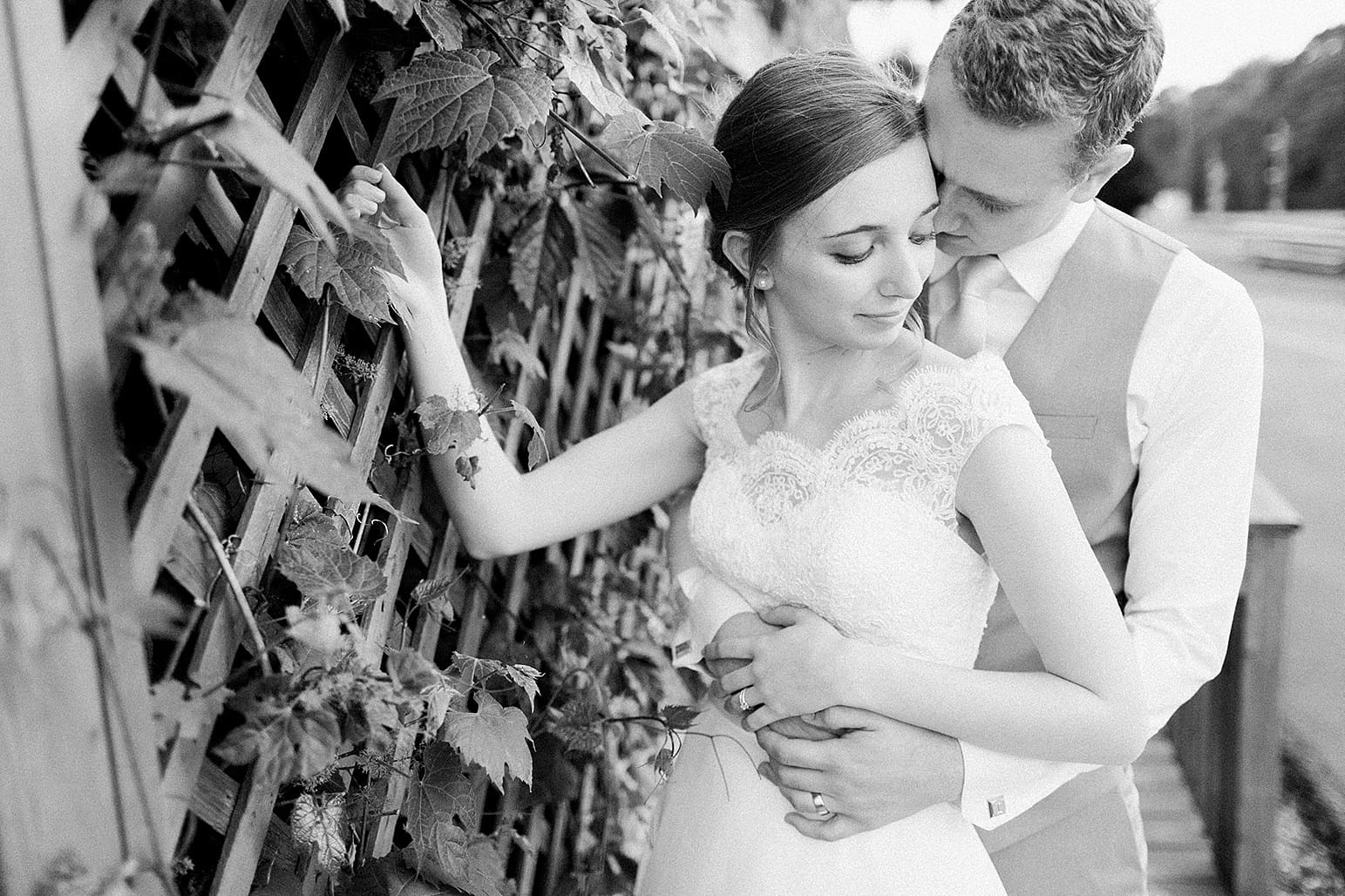 Arielle Peters Photography | Groom holding bride next to ivy lattice on wedding day at Lawton Lions Heritage Community Center in Lawton, Michigan.
