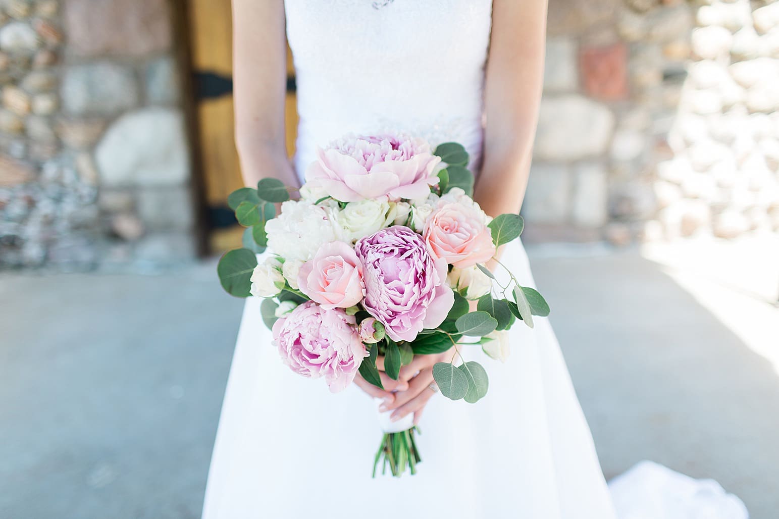Arielle Peters Photography | Bride holding peony bouquet in front of wooden cellar door on wedding day at Lawton Lions Heritage Community Center in Lawton, Michigan.