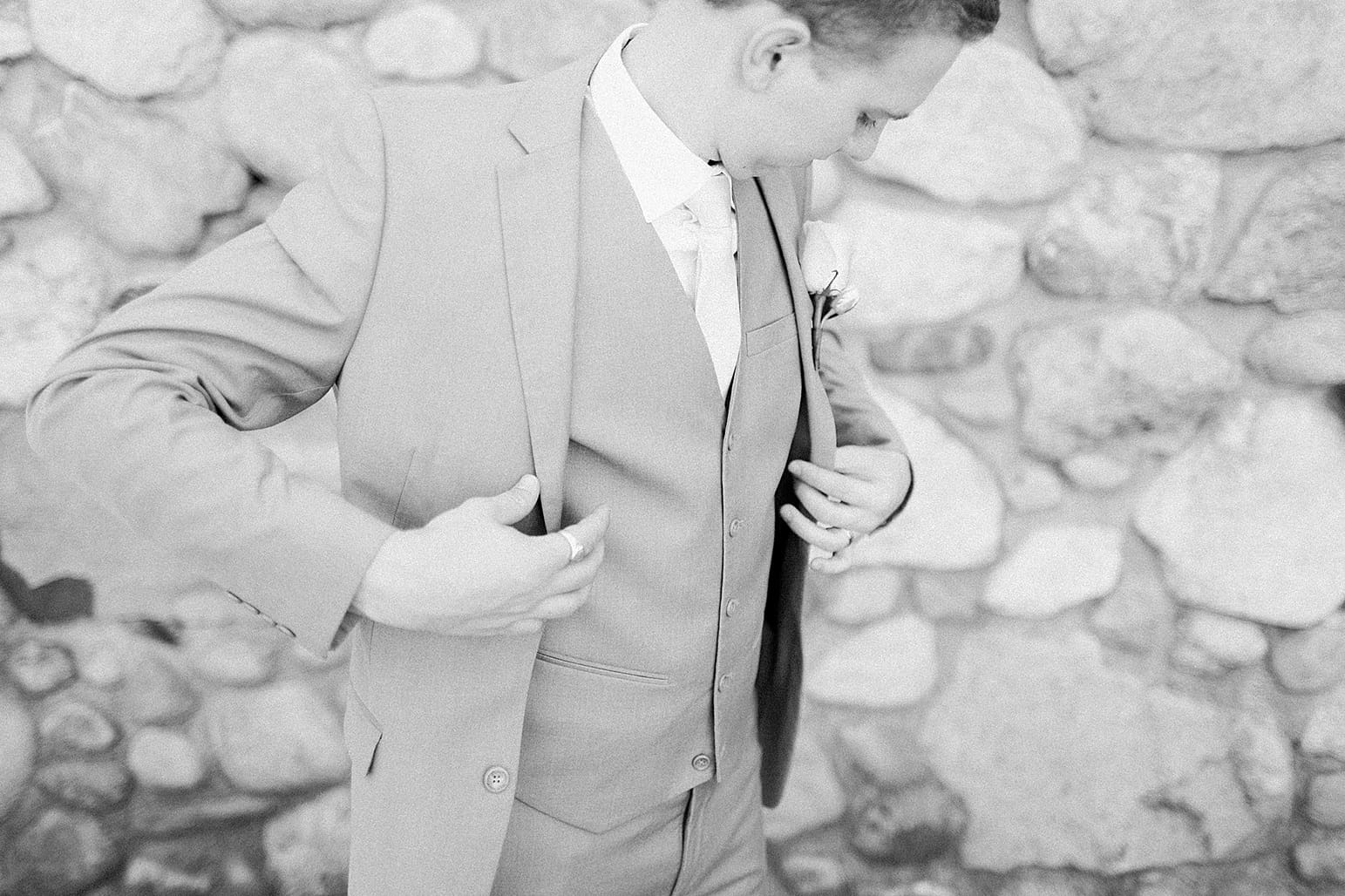 Arielle Peters Photography | Bride and groom in front of cobblestone wall on wedding day at Lawton Lions Heritage Community Center in Lawton, Michigan.