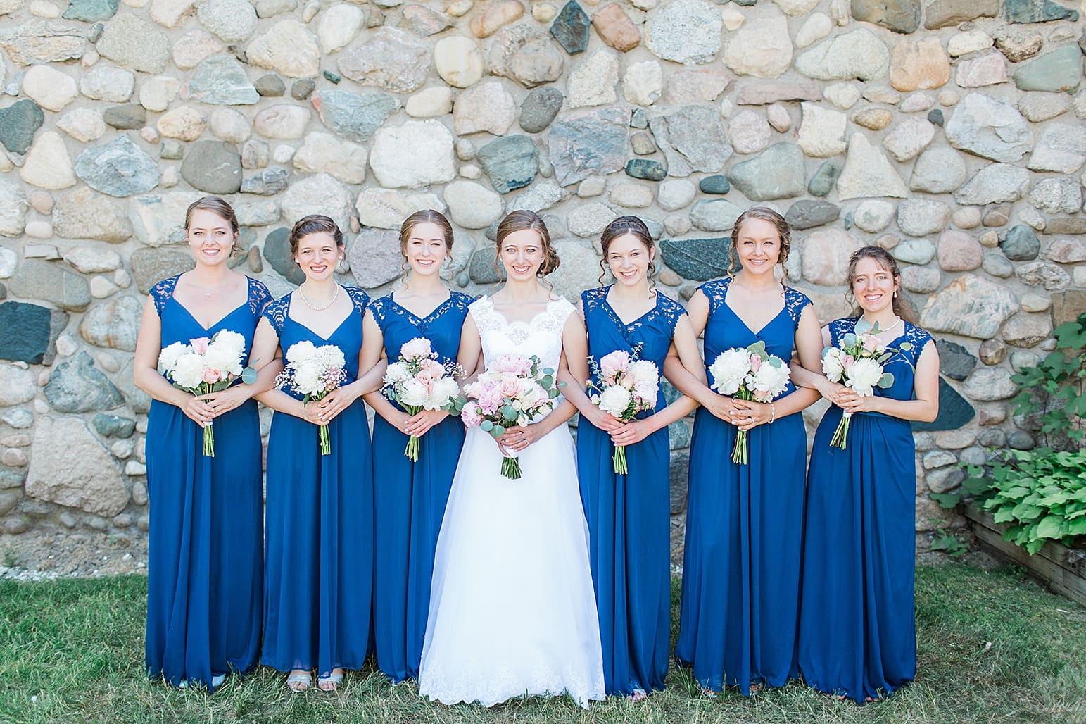 Arielle Peters Photography | Bride and bridesmaids next to historic cobblestone building on wedding day at Lawton Lions Heritage Community Center in Lawton, Michigan.