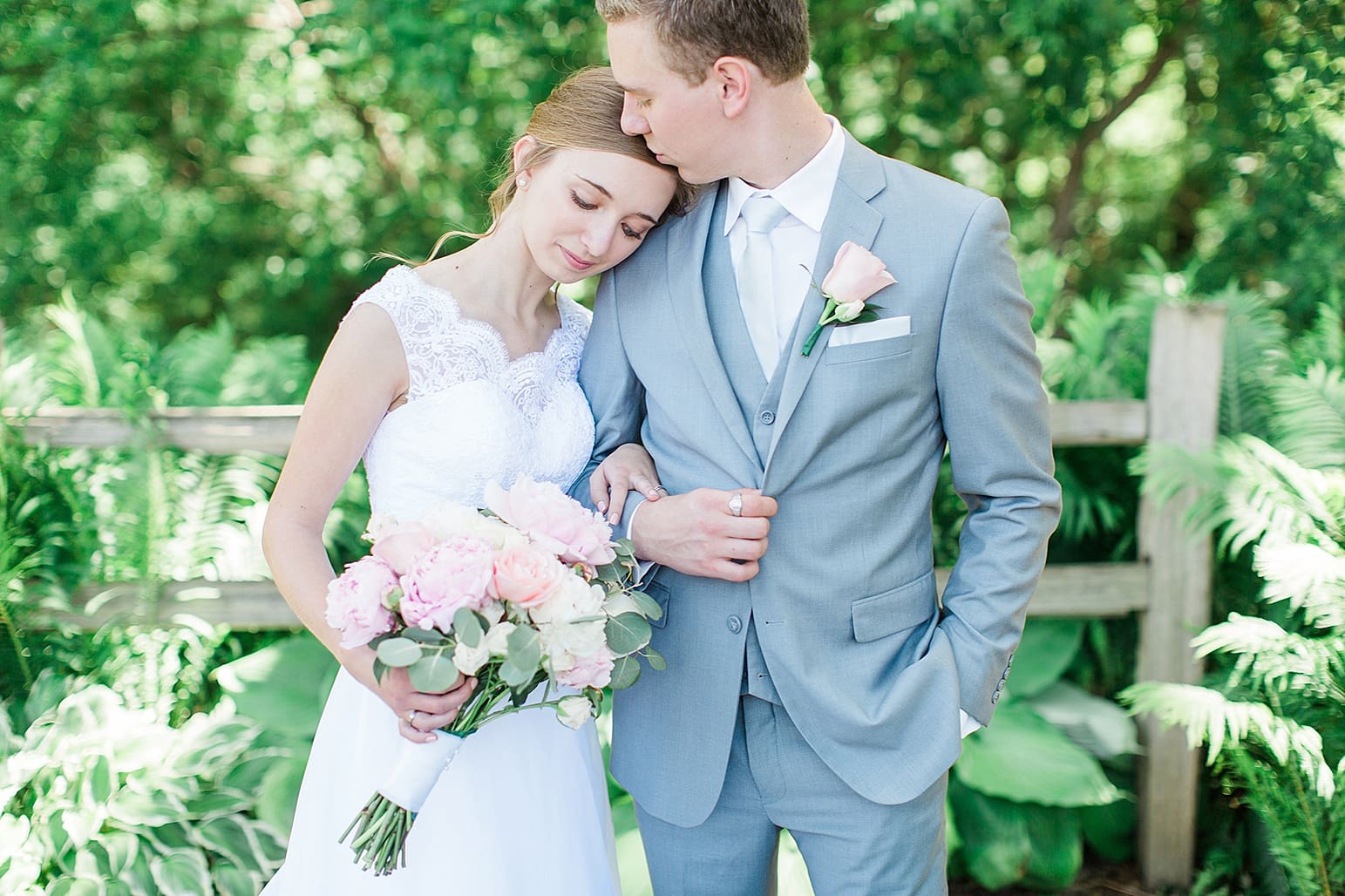 Arielle Peters Photography | Groom kissing bride's forehead in garden on wedding day at Lawton Lions Heritage Community Center in Lawton, Michigan.