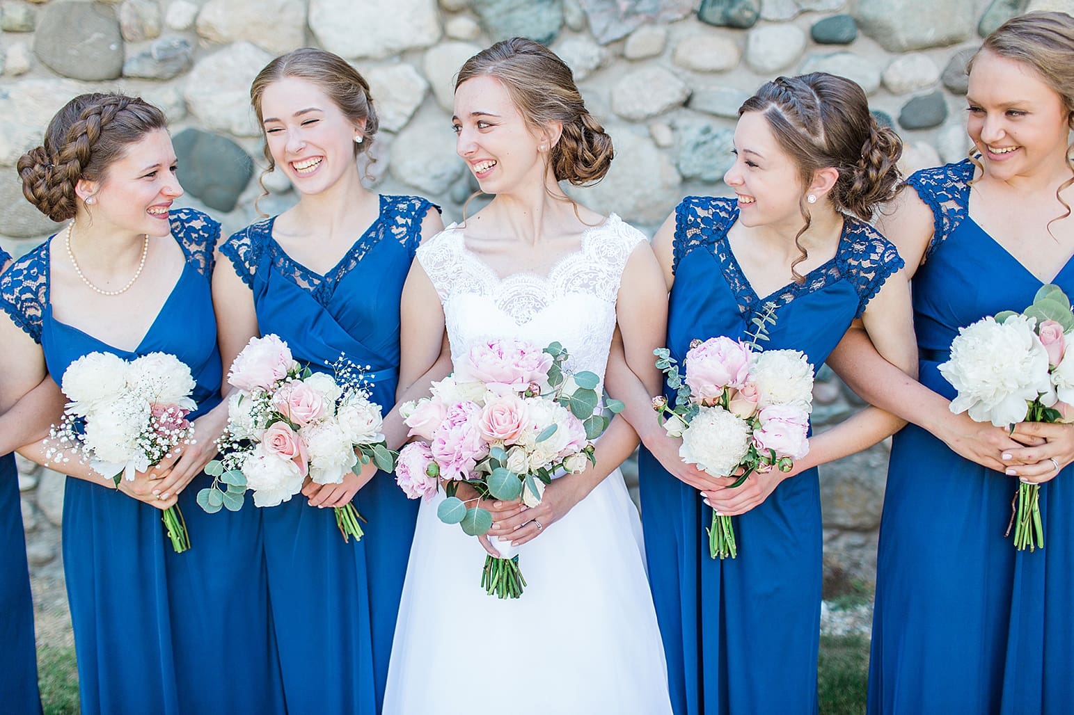 Arielle Peters Photography | Bride and bridesmaids next to historic cobblestone building on wedding day at Lawton Lions Heritage Community Center in Lawton, Michigan.