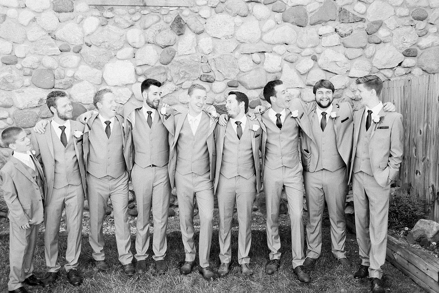 Arielle Peters Photography | Groom and groomsmen next to historic cobblestone building on wedding day at Lawton Lions Heritage Community Center in Lawton, Michigan.