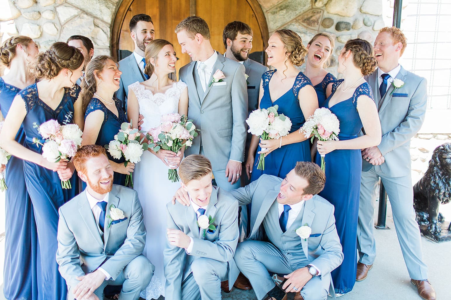 Arielle Peters Photography | Wedding party laughing next to wooden cellar door on wedding day at Lawton Lions Heritage Community Center in Lawton, Michigan.