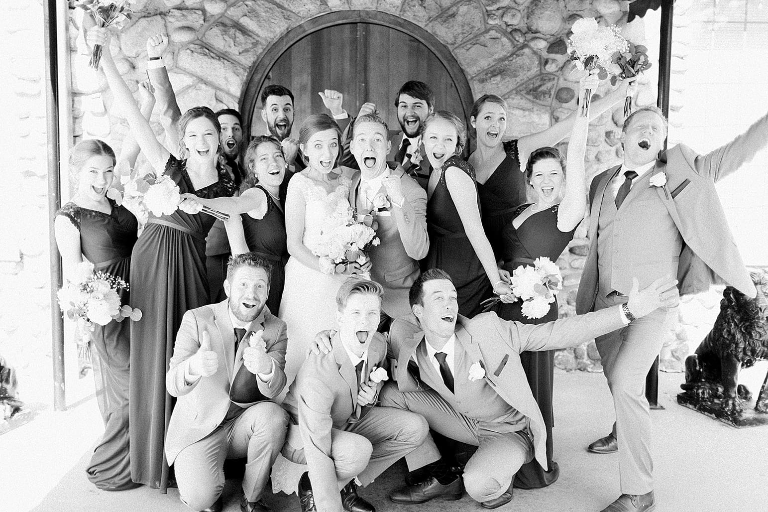 Arielle Peters Photography | Wedding party cheering in front of wooden cellar door on wedding day at Lawton Lions Heritage Community Center in Lawton, Michigan.