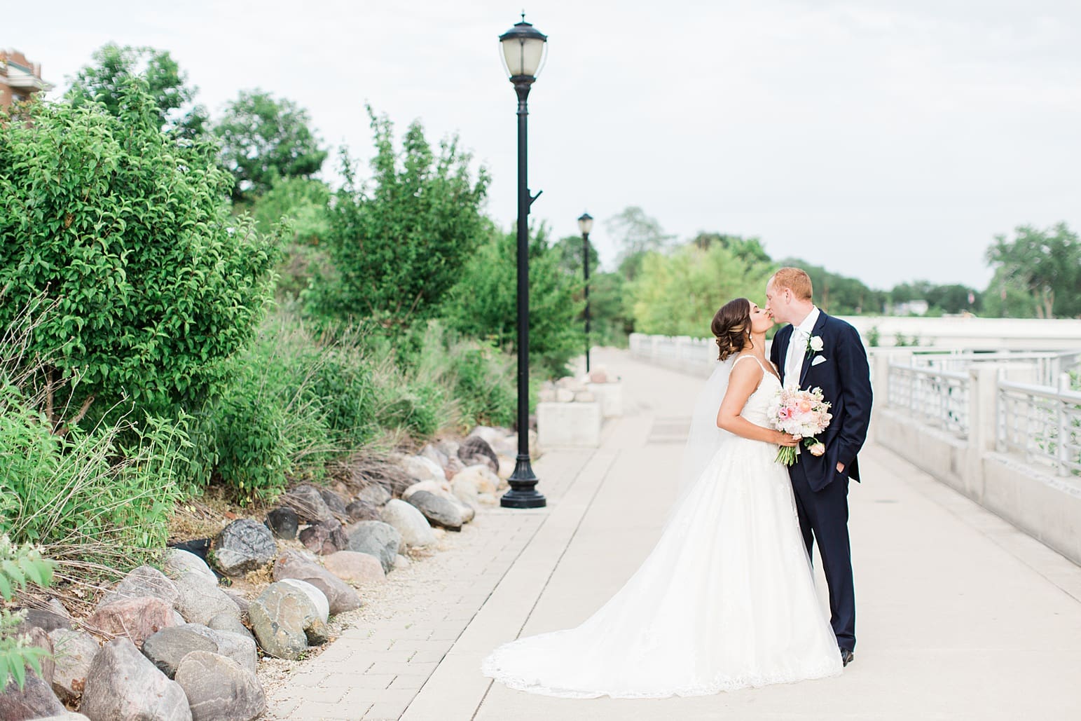 Arielle Peters Photography | Bride and groom kissing next to lake on wedding day at First United Methodist Church in Mishawaka, Indiana.