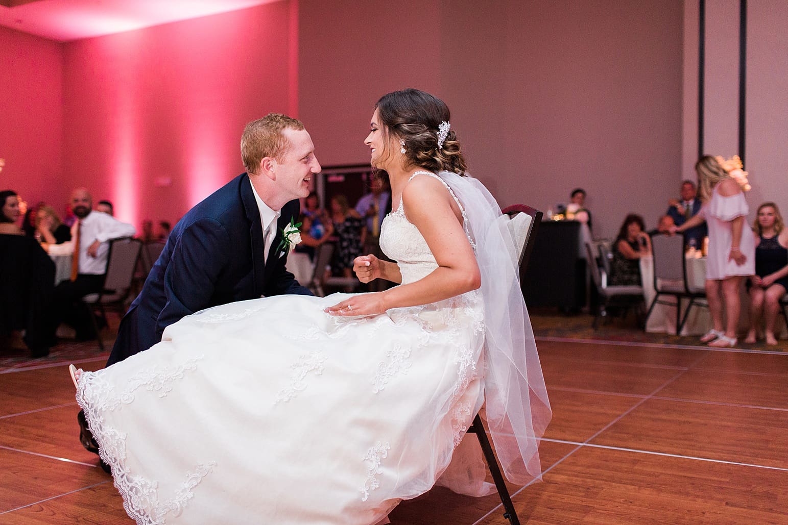 Arielle Peters Photography | Groom finding bride's garter at wedding reception at the Holiday Inn in Mishawaka, Indiana.