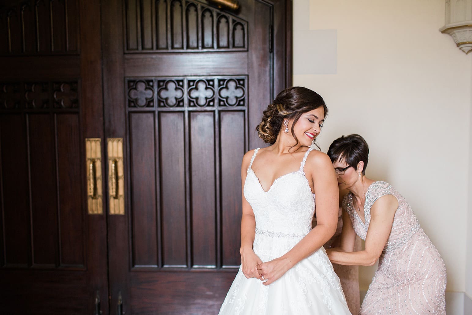 Arielle Peters Photography | Mother of the bride helping bride put on wedding dress on wedding day at First United Methodist Church in Mishawaka, Indiana.