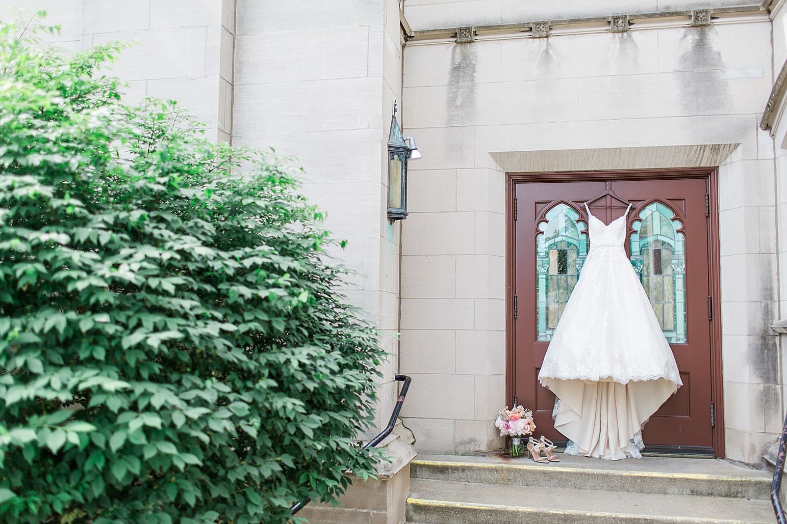 Arielle Peters Photography | Wedding gown hanging on cathedral church doors on wedding day at First United Methodist Church in Mishawaka, Indiana.