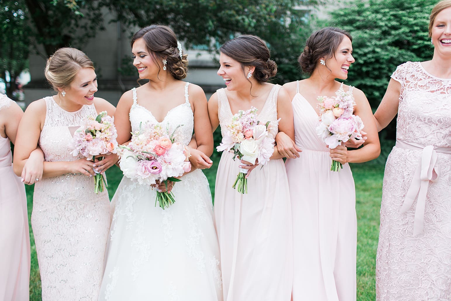 Arielle Peters Photography | Bride and bridesmaids under tree outside large cathedral church on wedding day at First United Methodist Church in Mishawaka, Indiana.