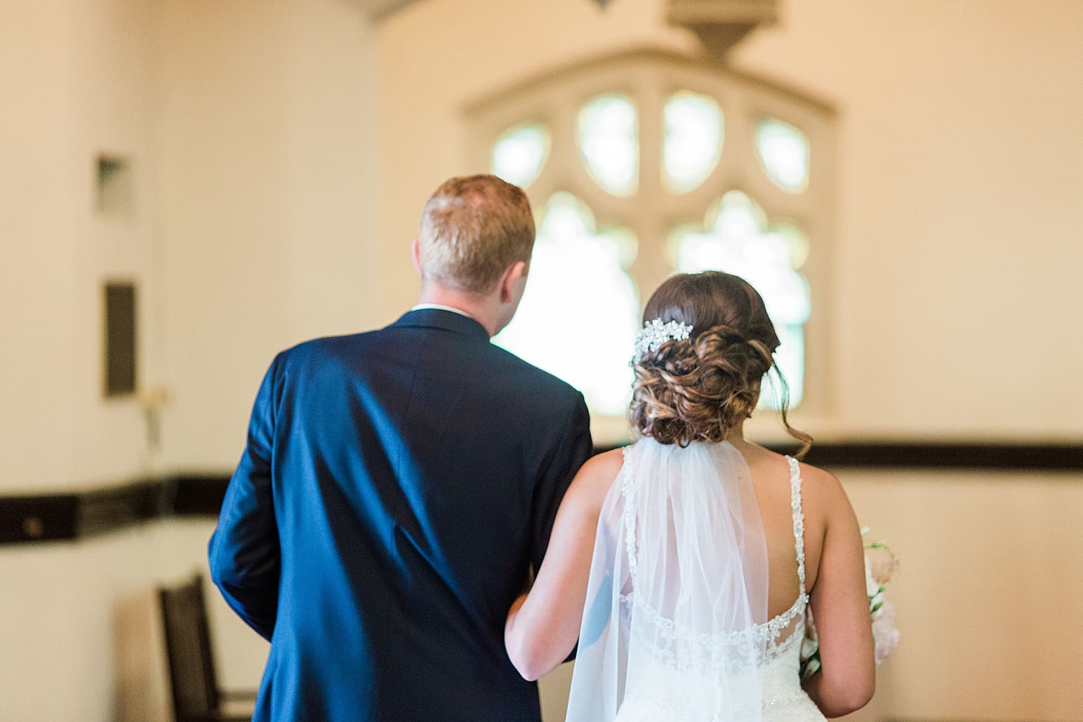 Arielle Peters Photography | Bride and groom walking arm in arm on wedding day at First United Methodist Church in Mishawaka, Indiana.