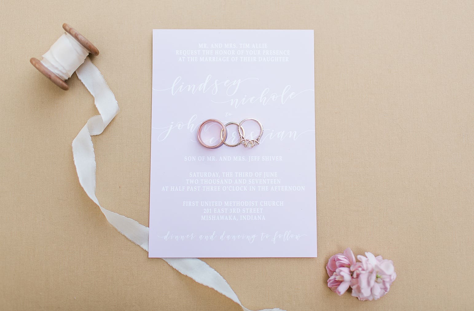Arielle Peters Photography | Wedding rings lying on invitations on wedding day at First United Methodist Church in Mishawaka, Indiana.