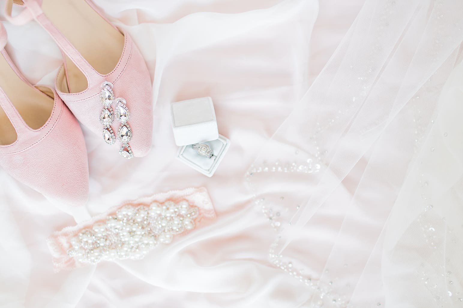 Arielle Peters Photography | Pink wedding shoes and jewelry on white background on wedding day at St. Joseph County Parks in South Bend, Indiana.