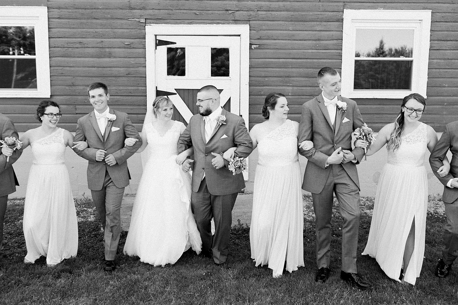 Arielle Peters Photography | Wedding party walking next to old red barn on wedding day at St. Joseph County Parks in South Bend, Indiana.