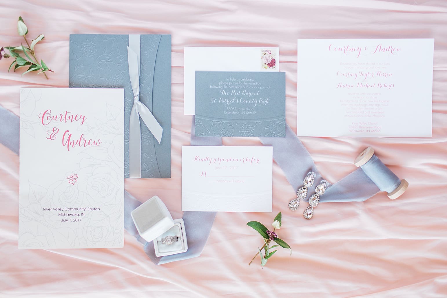 Arielle Peters Photography | Wedding invitations and jewelry on soft pink background on wedding day at St. Joseph County Parks in South Bend, Indiana.