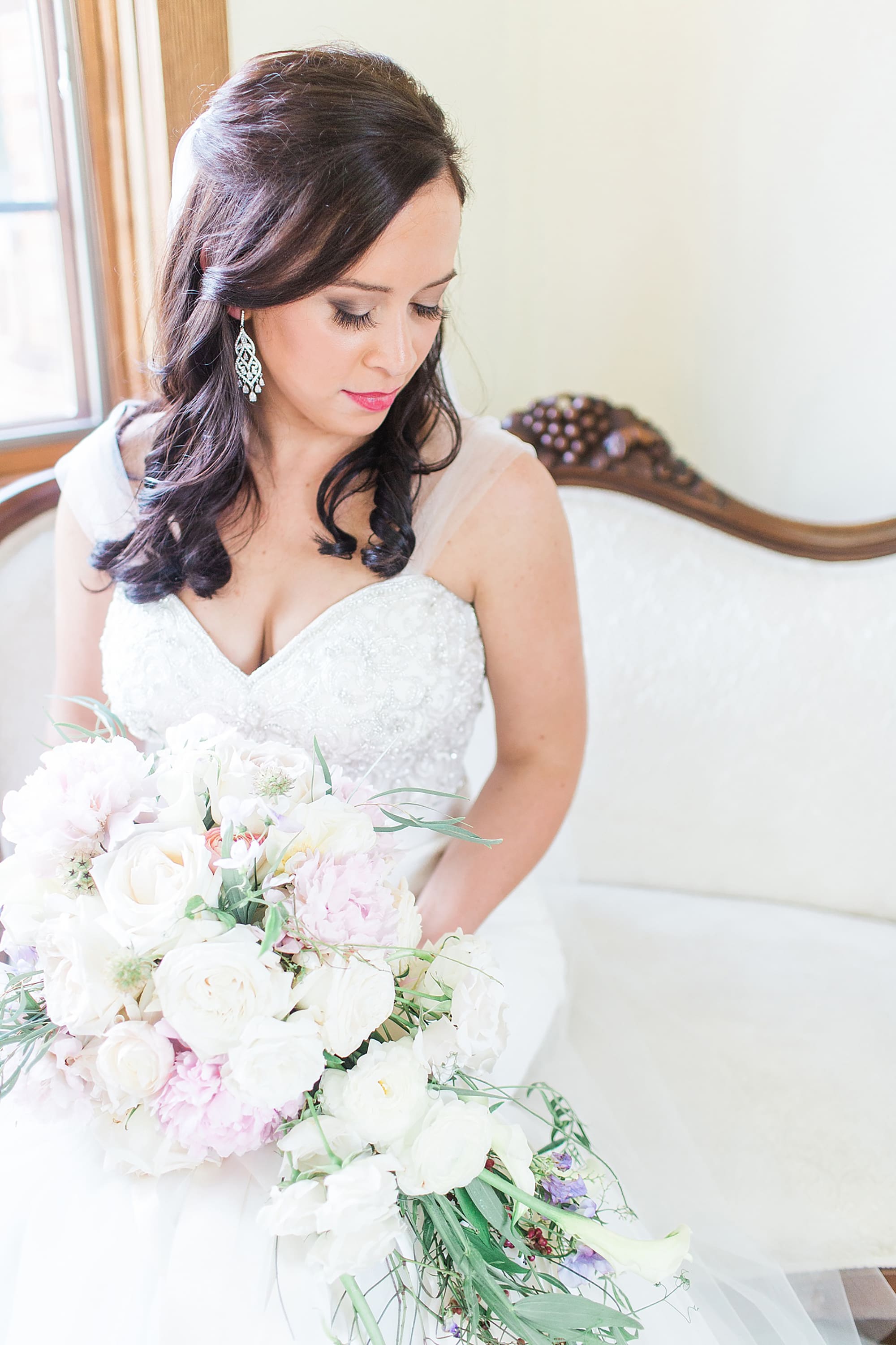 Arielle Peters Photography | Bride sitting in her dress on couch on wedding day photos at Nazareth Hall in Grand Rapids, Ohio. 
