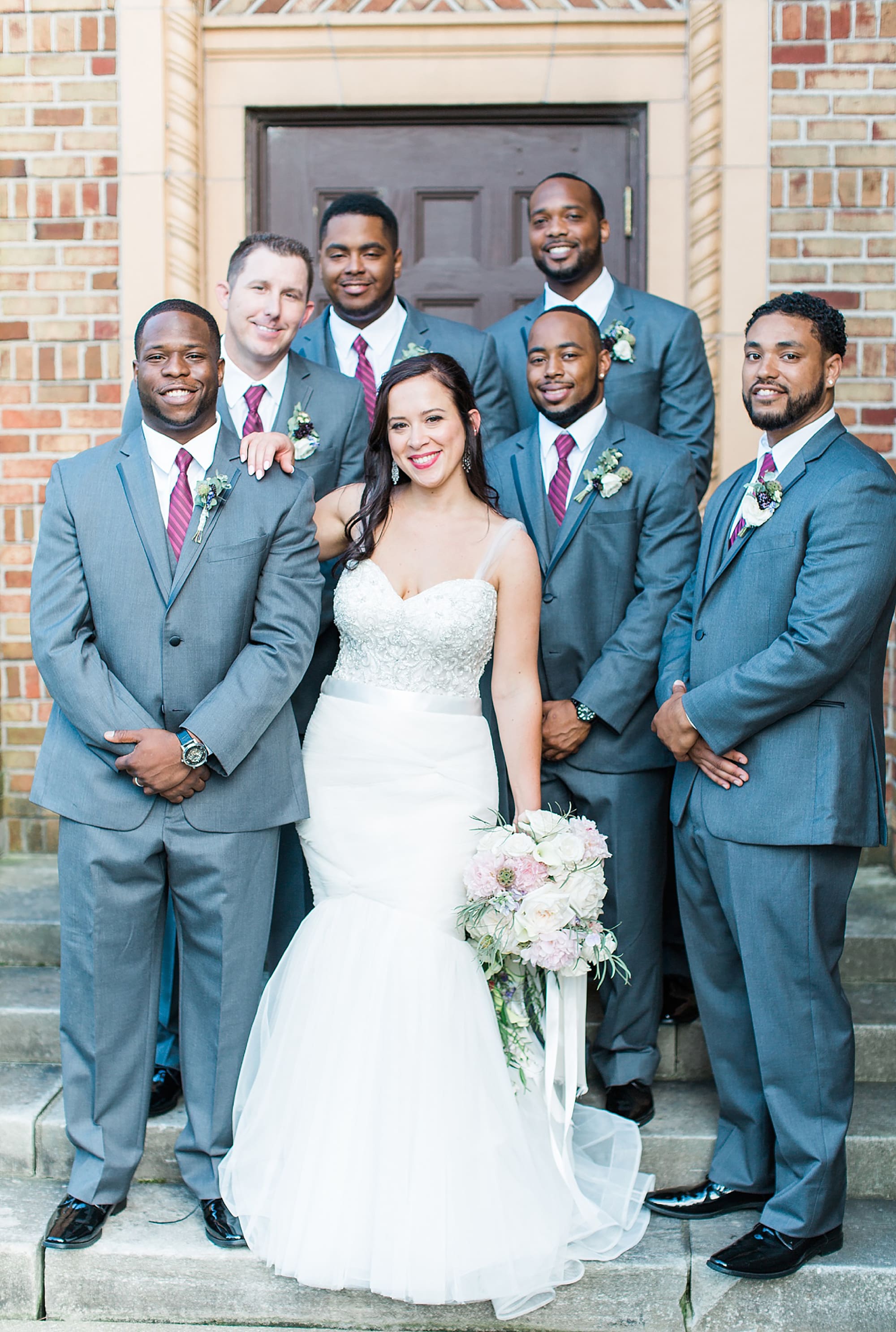 Arielle Peters Photography | Bride and groomsmen next to brick building on wedding day photos at Nazareth Hall in Grand Rapids, Ohio. 