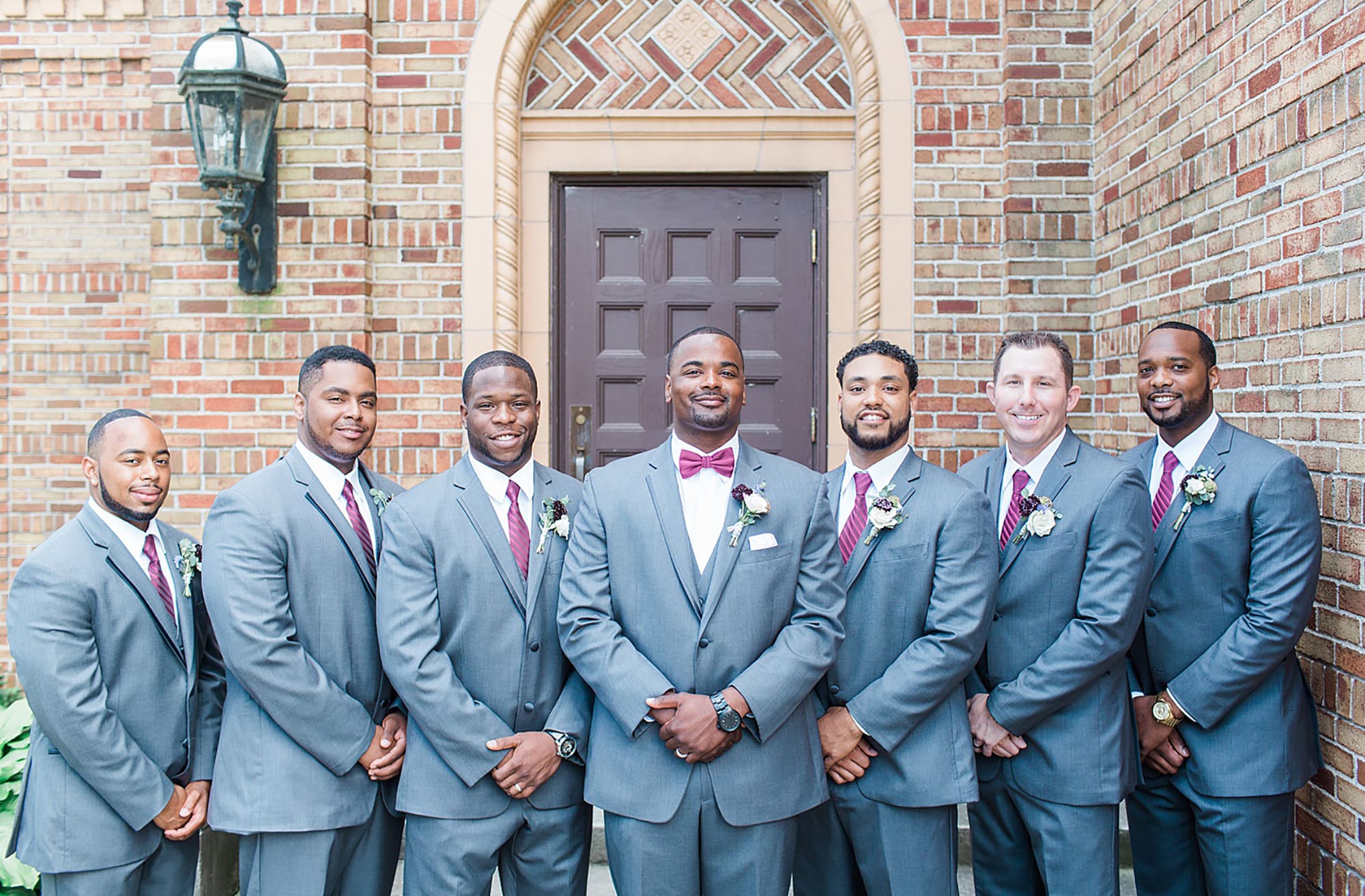 Arielle Peters Photography | Groom and groomsmen next to brick building on wedding day photos at Nazareth Hall in Grand Rapids, Ohio. 