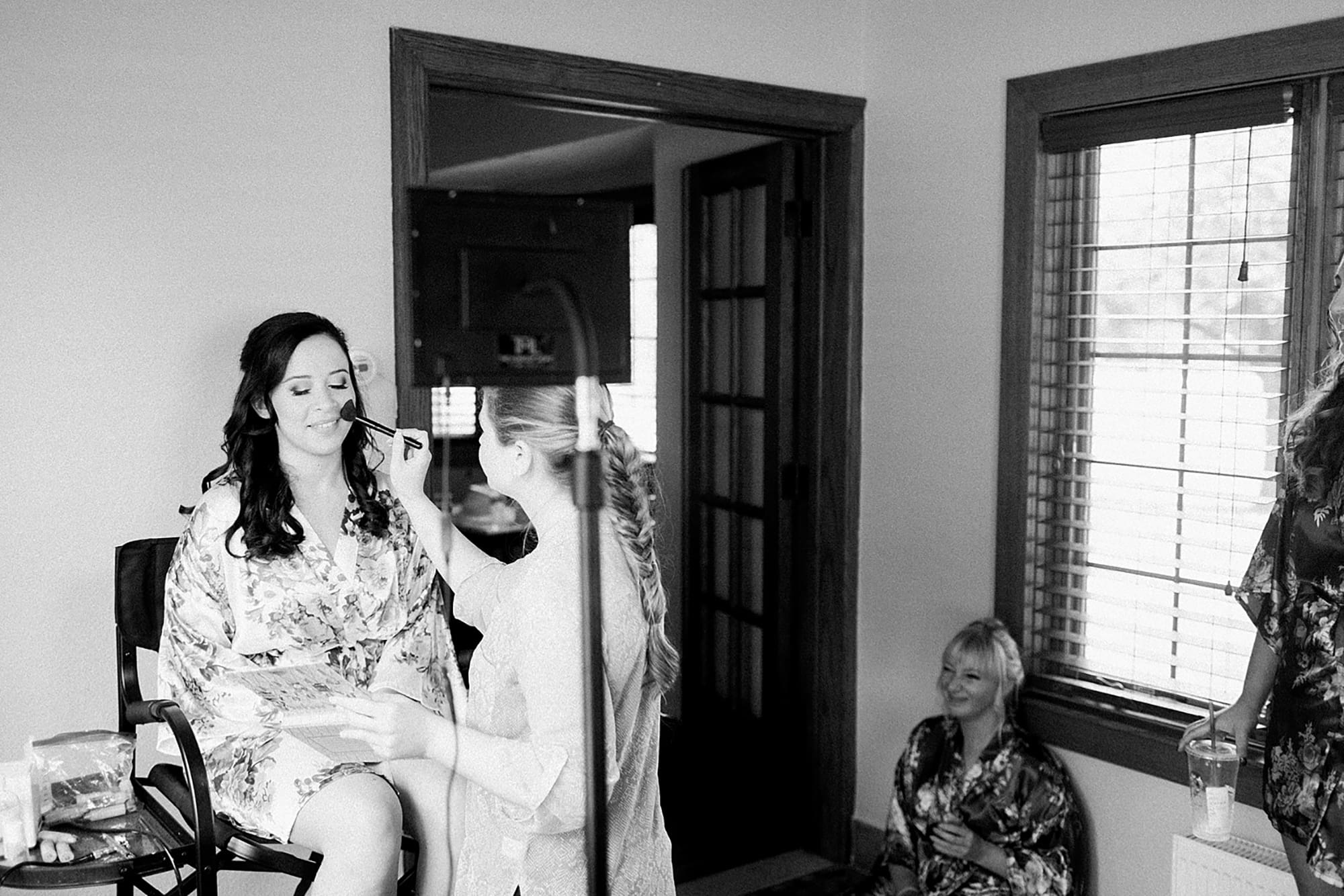 Arielle Peters Photography | Bride and bridesmaids in robes getting their makeup done on wedding day photos at Nazareth Hall in Grand Rapids, Ohio. 