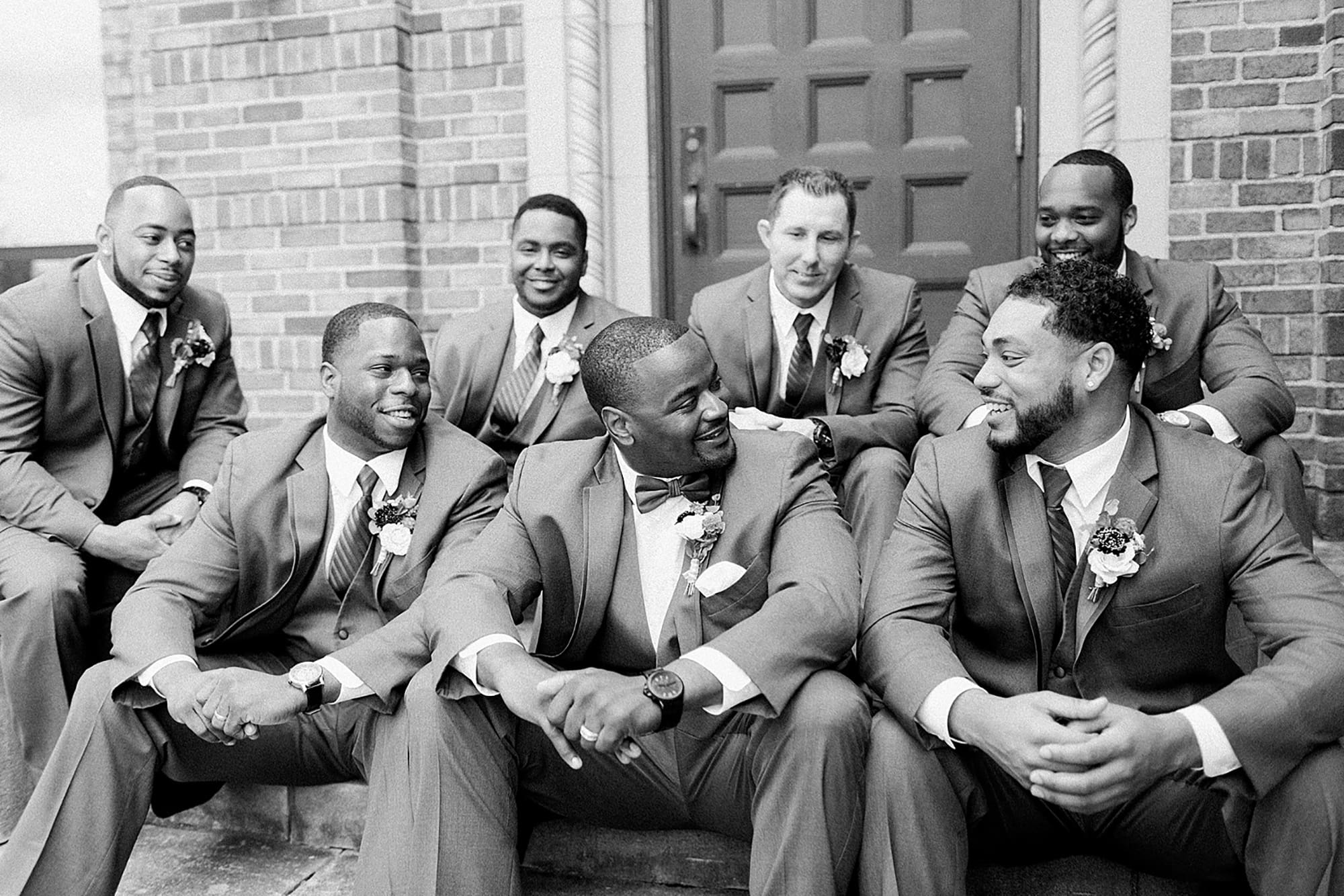 Arielle Peters Photography | Groom and groomsmen sitting on brick steps on wedding day photos at Nazareth Hall in Grand Rapids, Ohio. 