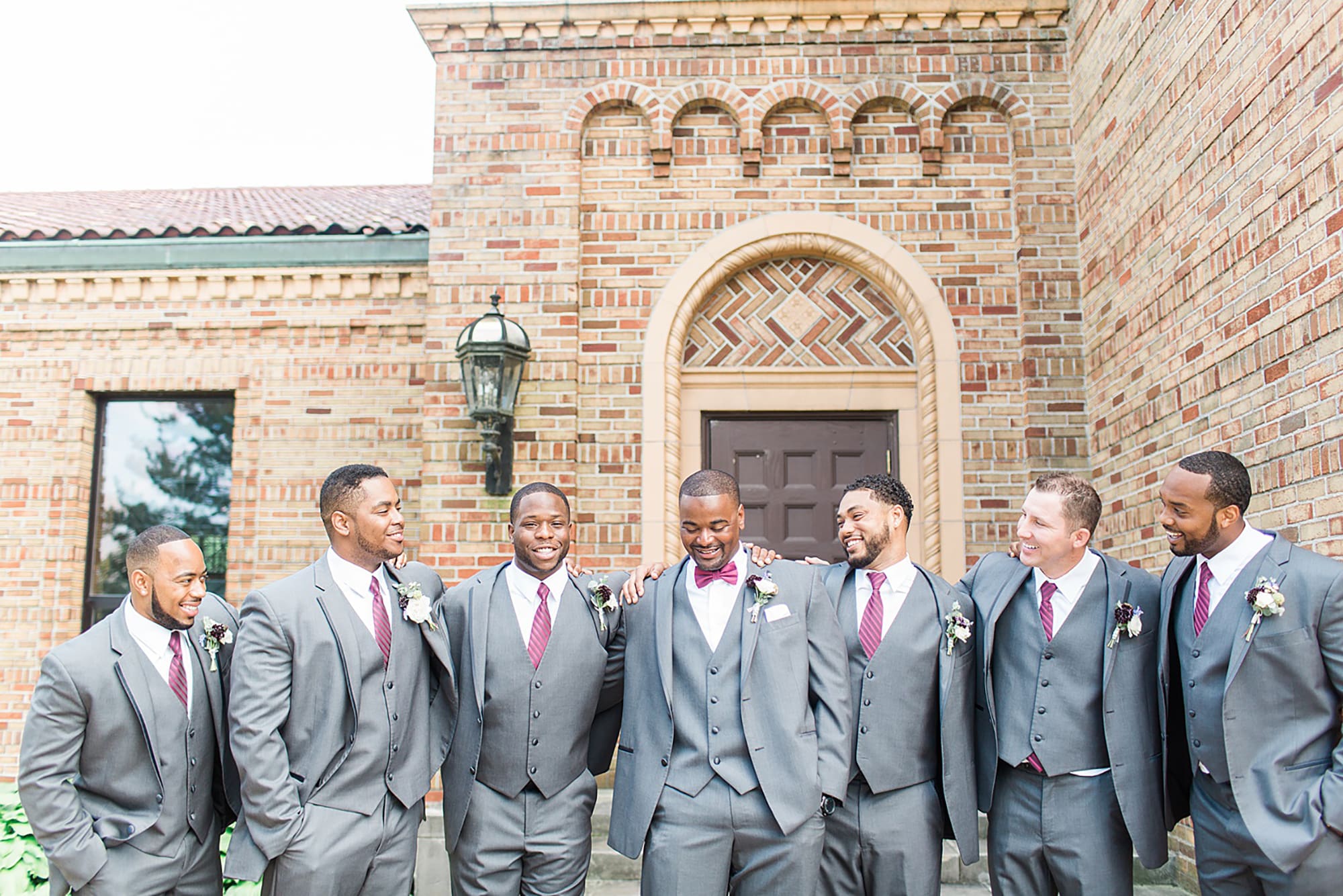 Arielle Peters Photography | Groom and groomsmen next to brick building on wedding day photos at Nazareth Hall in Grand Rapids, Ohio. 