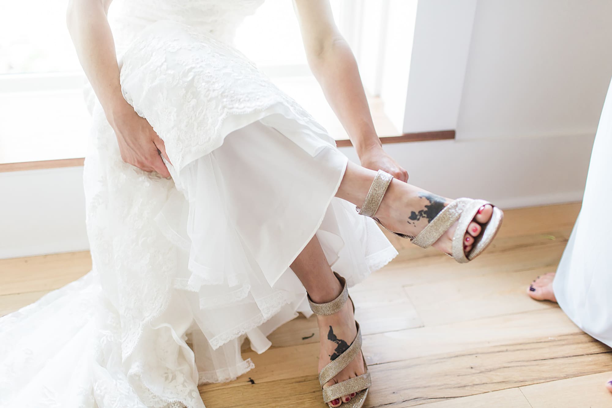Arielle Peters Photography | Bride putting on wedding shoes on wedding day at Winona Heritage Room in Winona Lake, Indiana.