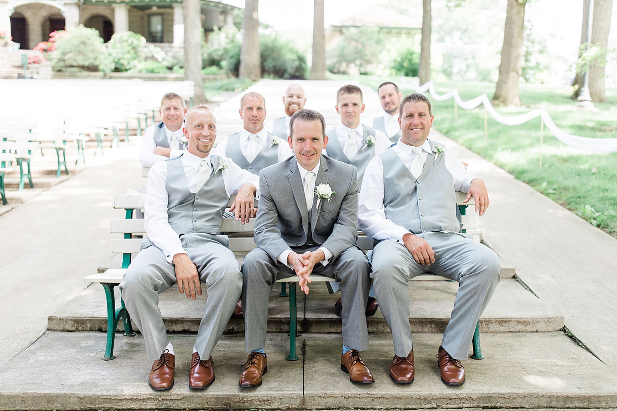 Arielle Peters Photography | Groom and groomsmen on benches in park on wedding day at Winona Heritage Room in Winona Lake, Indiana.