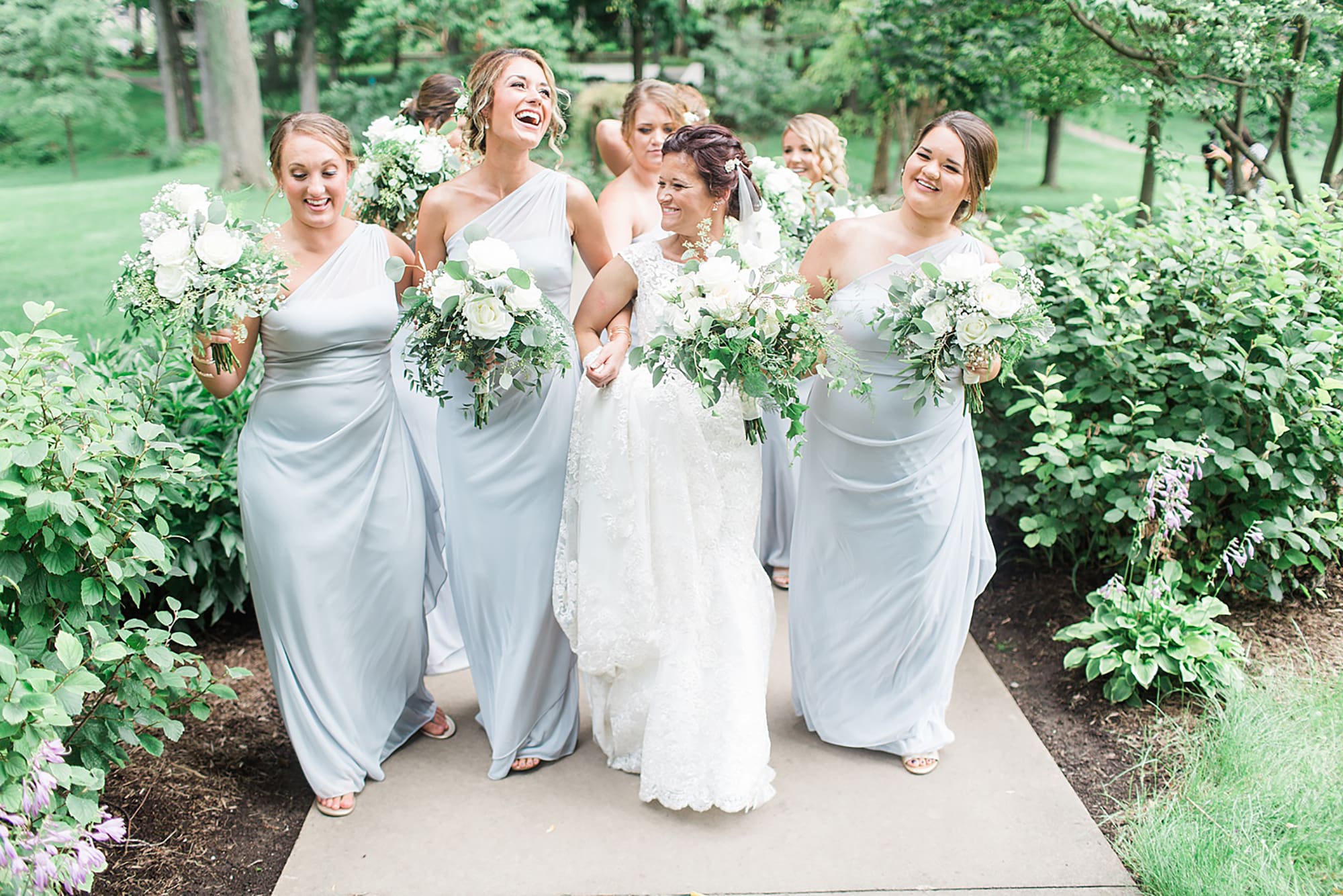 Arielle Peters Photography | Bride and bridesmaids walking through garden on wedding day at Winona Heritage Room in Winona Lake, Indiana.