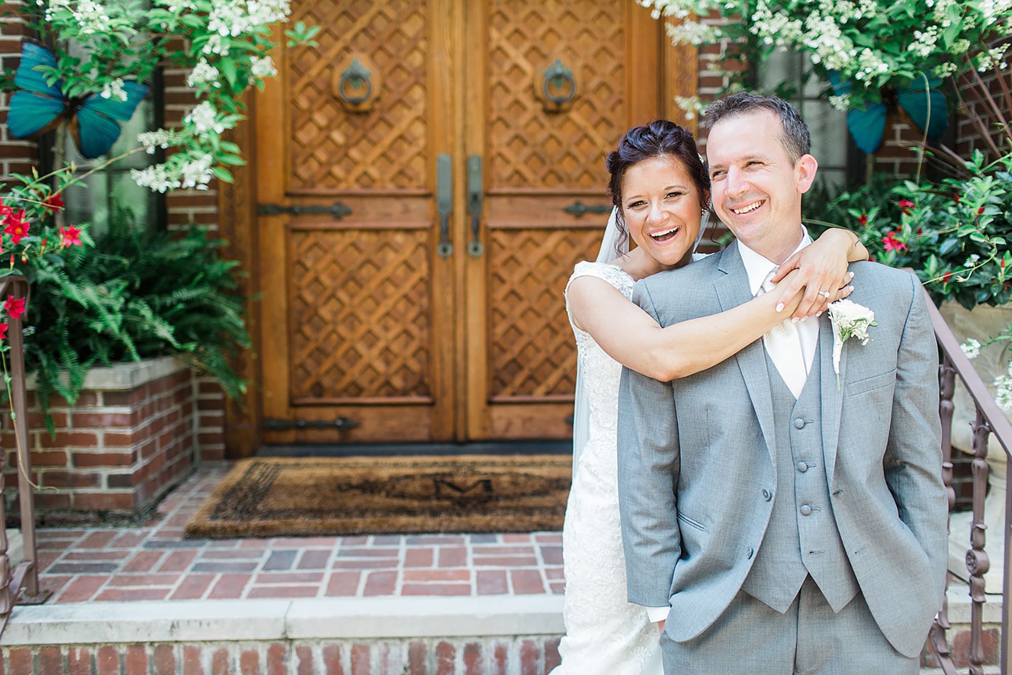Arielle Peters Photography | Bride and groom laughing next to wooden door on wedding day at Winona Heritage Room in Winona Lake, Indiana.
