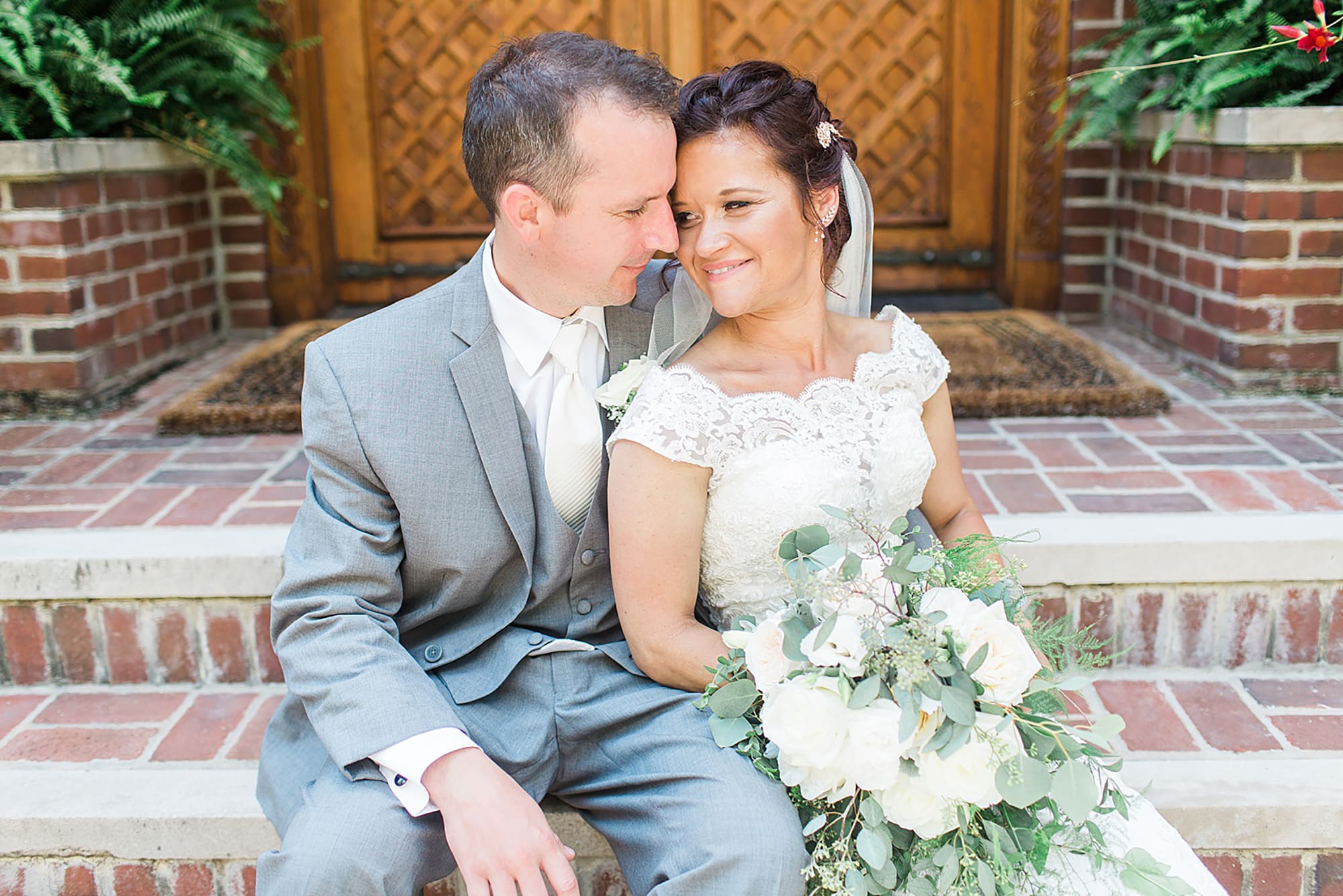 Arielle Peters Photography | Bride and groom sitting on brick stairs on wedding day at Winona Heritage Room in Winona Lake, Indiana.
