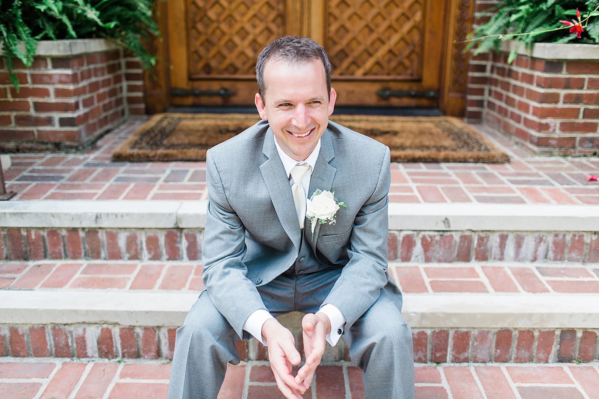 Arielle Peters Photography | Groom sitting on brick stairs on wedding day at Winona Heritage Room in Winona Lake, Indiana.