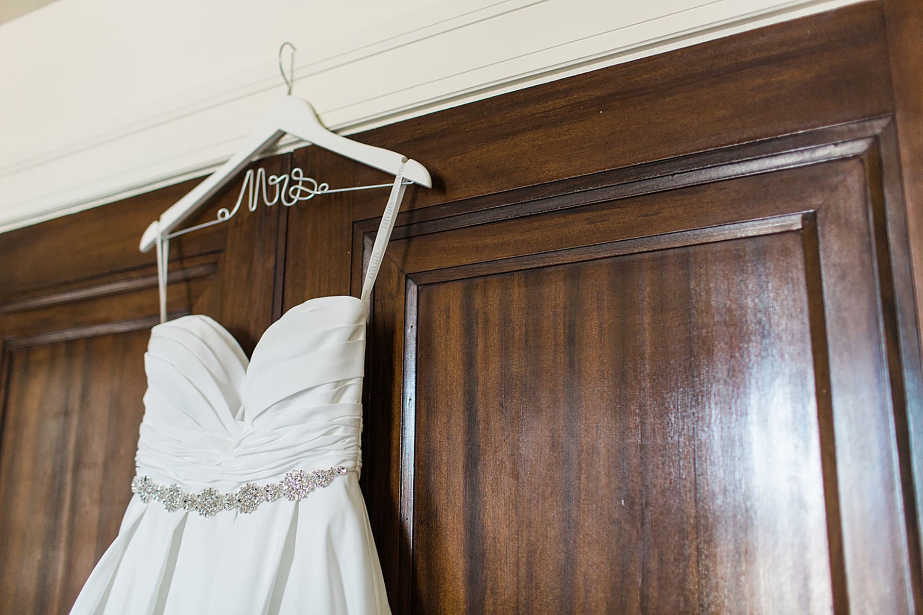 Arielle Peters Photography | Wedding dress hanging in wooden doorway on wedding day at the Freemasons Hall in Fort Wayne, Indiana.