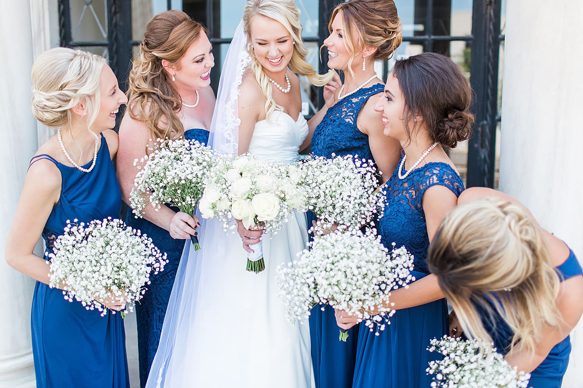 Arielle Peters Photography | Bride and bridesmaids next to church columns on wedding day at the Freemasons Hall in Fort Wayne, Indiana.