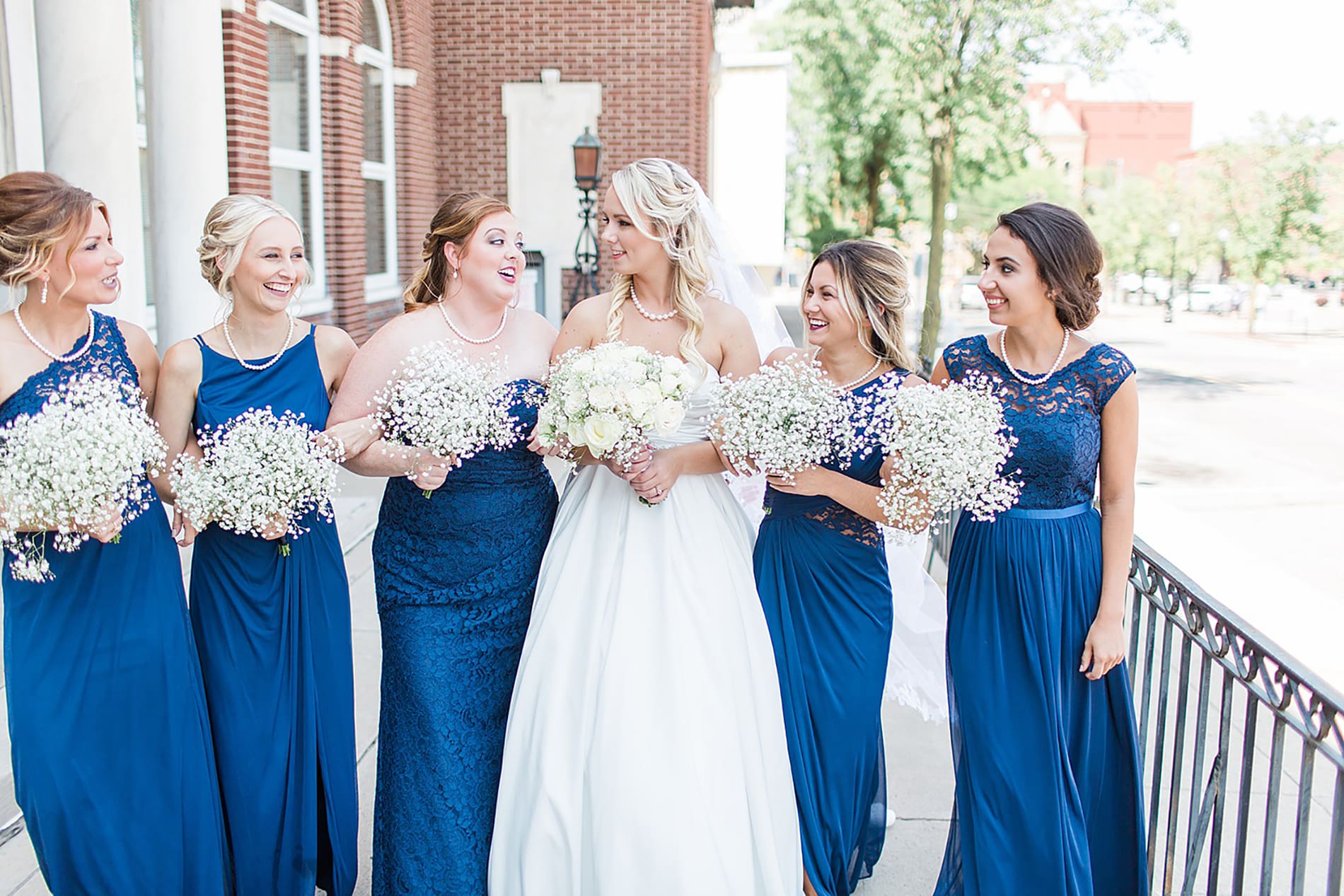 Arielle Peters Photography | Bride and bridesmaids walking by church on wedding day at the Freemasons Hall in Fort Wayne, Indiana.