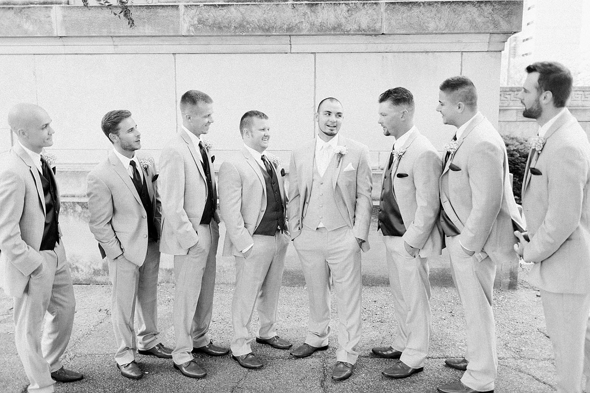 Arielle Peters Photography | Groom and groomsmen laughing next to church on wedding day at the Freemasons Hall in Fort Wayne, Indiana.