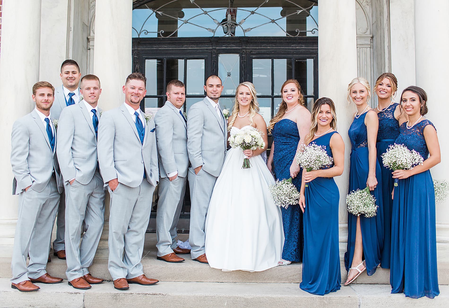 Arielle Peters Photography | Wedding party standing next to limestone building on wedding day at the Freemasons Hall in Fort Wayne, Indiana.